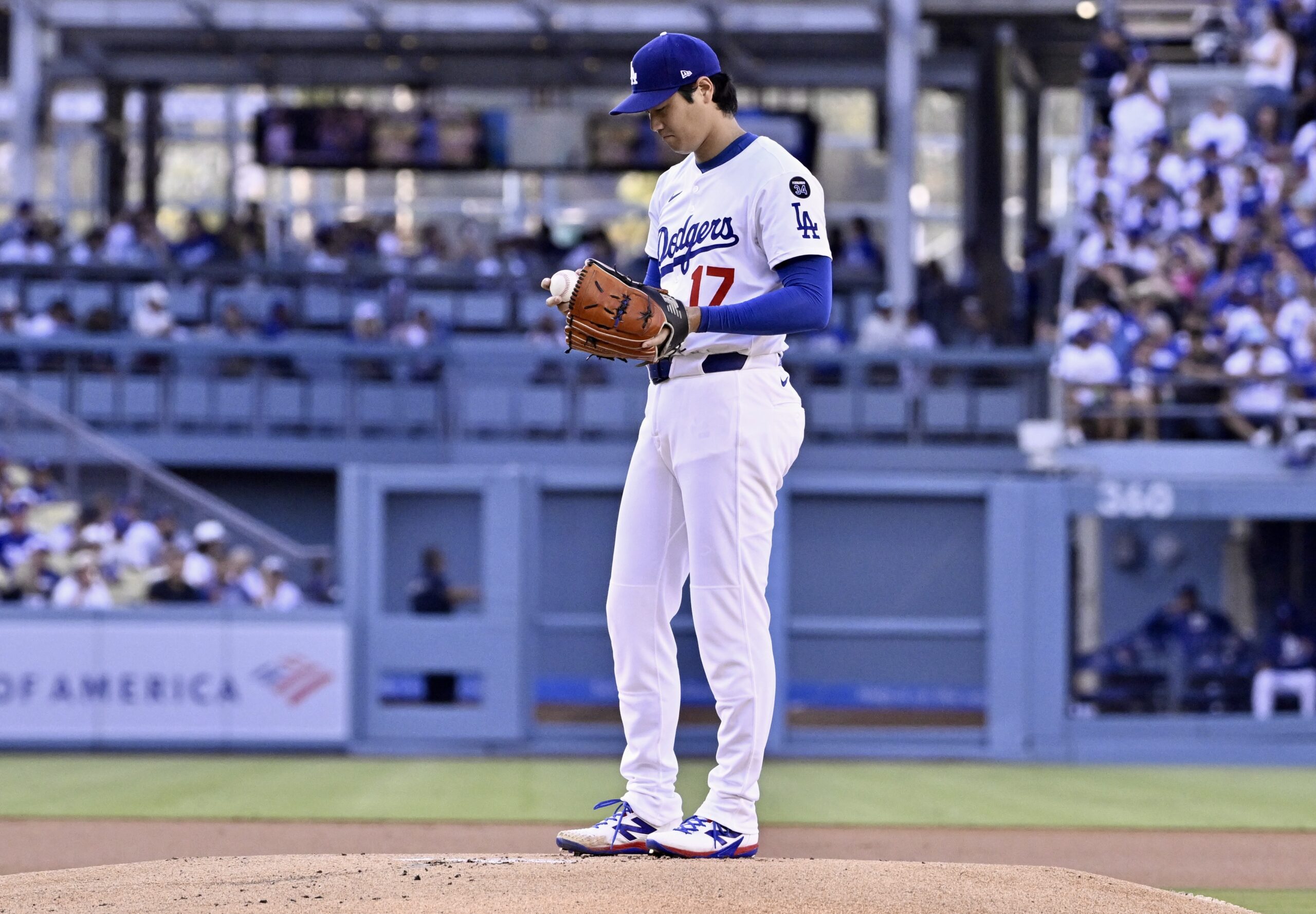 Dodgers starting pitcher Shohei Ohtani looks at the baseball before...