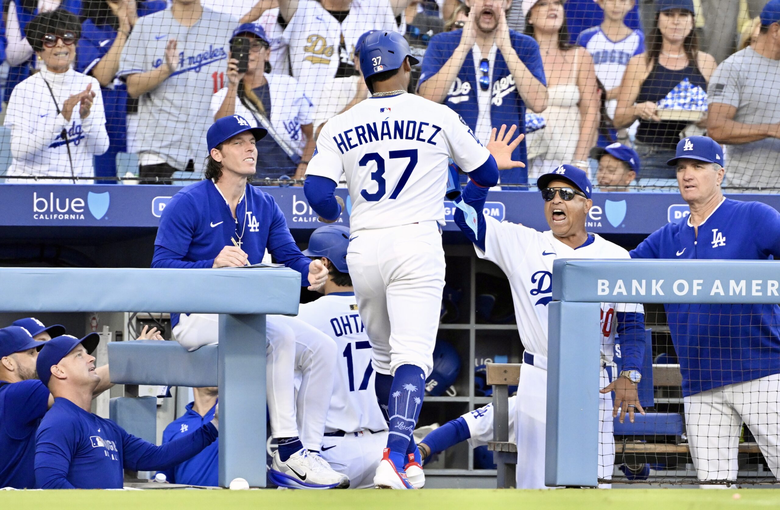 The Dodgers’ Teoscar Hernández (37) high-fives Manager Dave Roberts as...