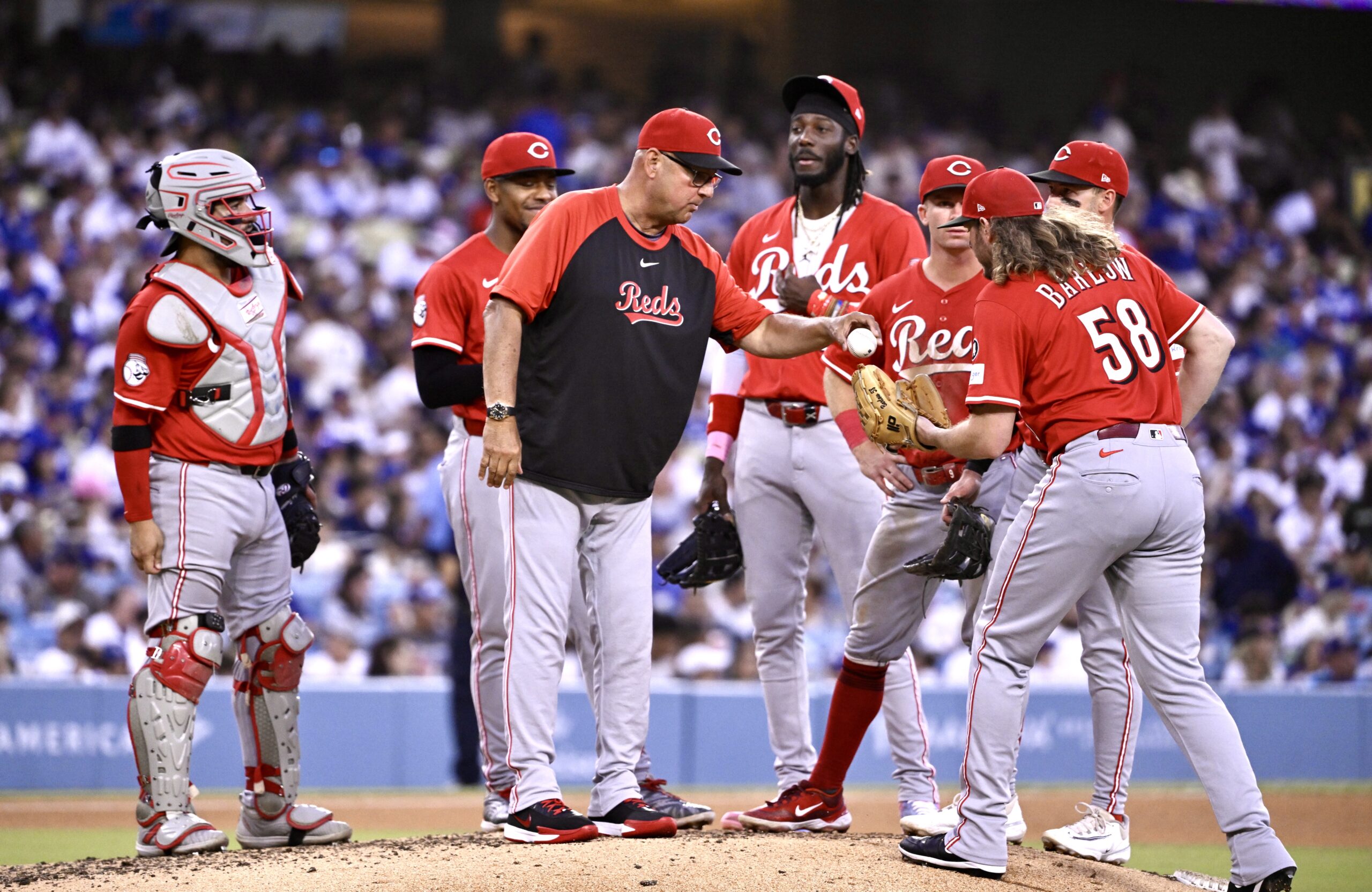 Cincinnati Reds manager Terry Francona, center, hands the ball to...