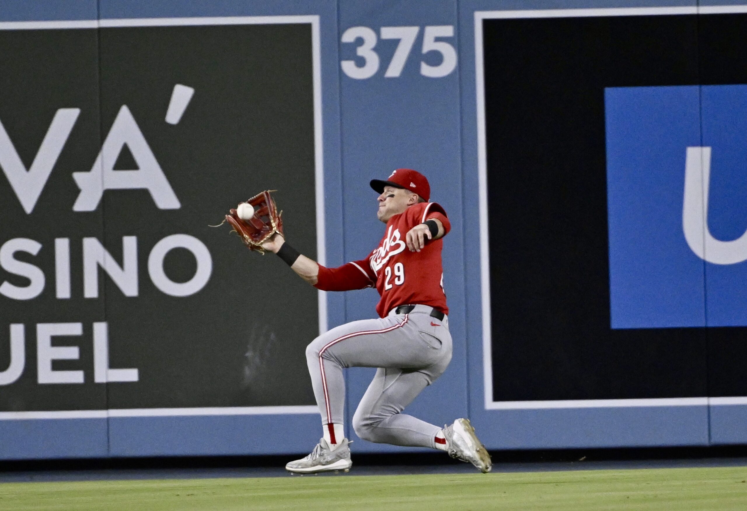 Cincinnati Reds center fielder TJ Friedl makes a sliding catch...