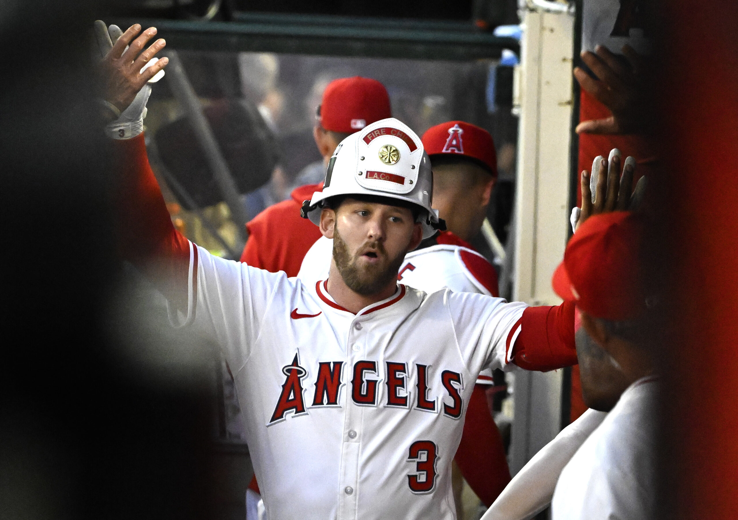 The Angels’ Taylor Ward celebrates in the dugout after hitting...