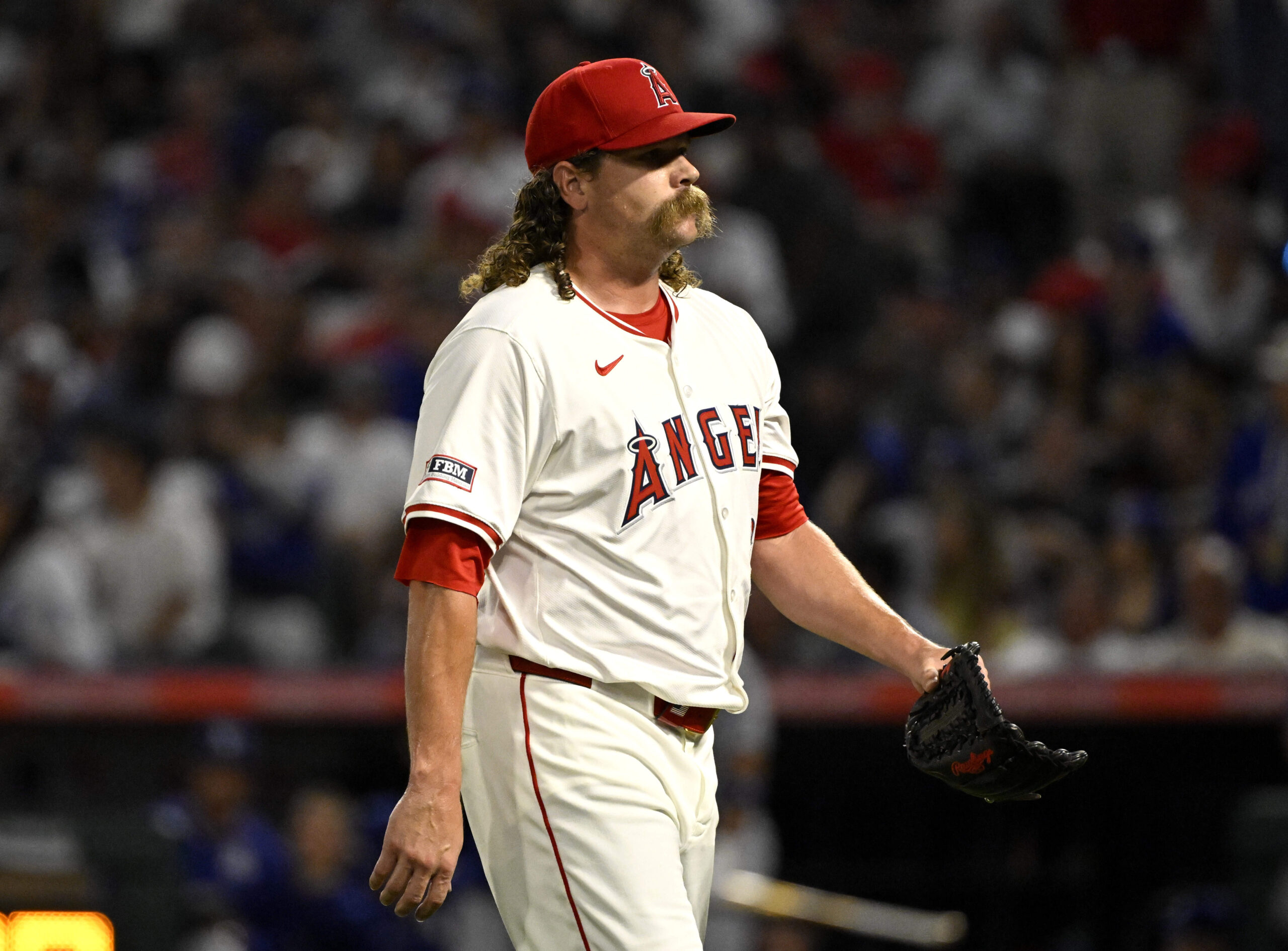 Angels relief pitcher Andrew Chafin walks off the field after...