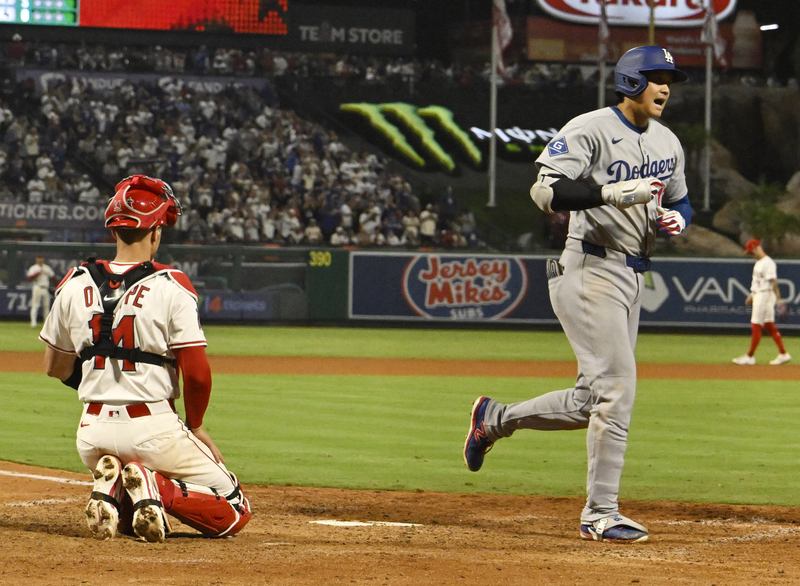 Dodgers star Shohei Ohtani crosses home plate after hitting a...
