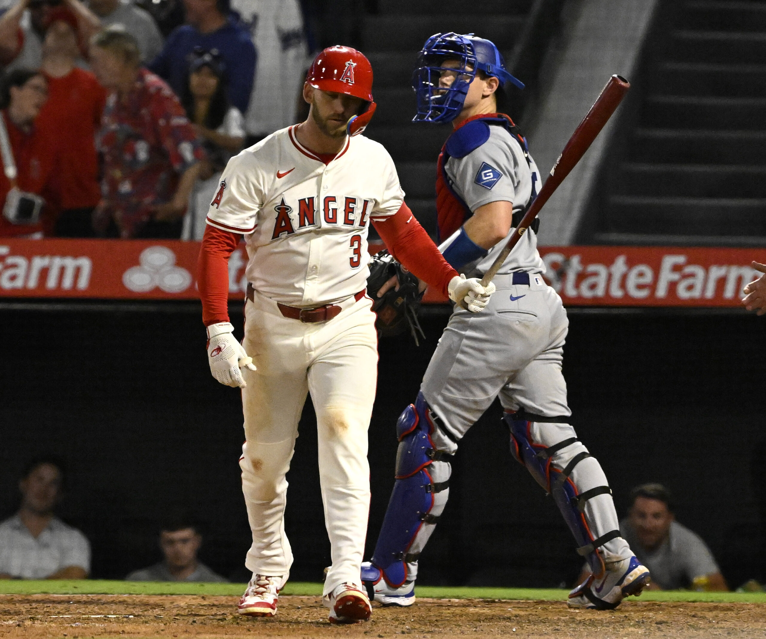 The Angels’ Taylor Ward, left, walks back to the dugout...