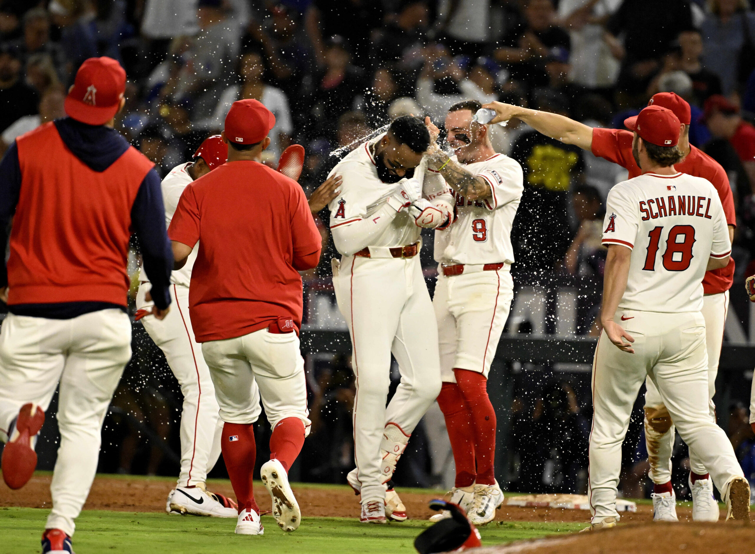 The Angels’ Jo Adell (7) celebrates with teammates after his...