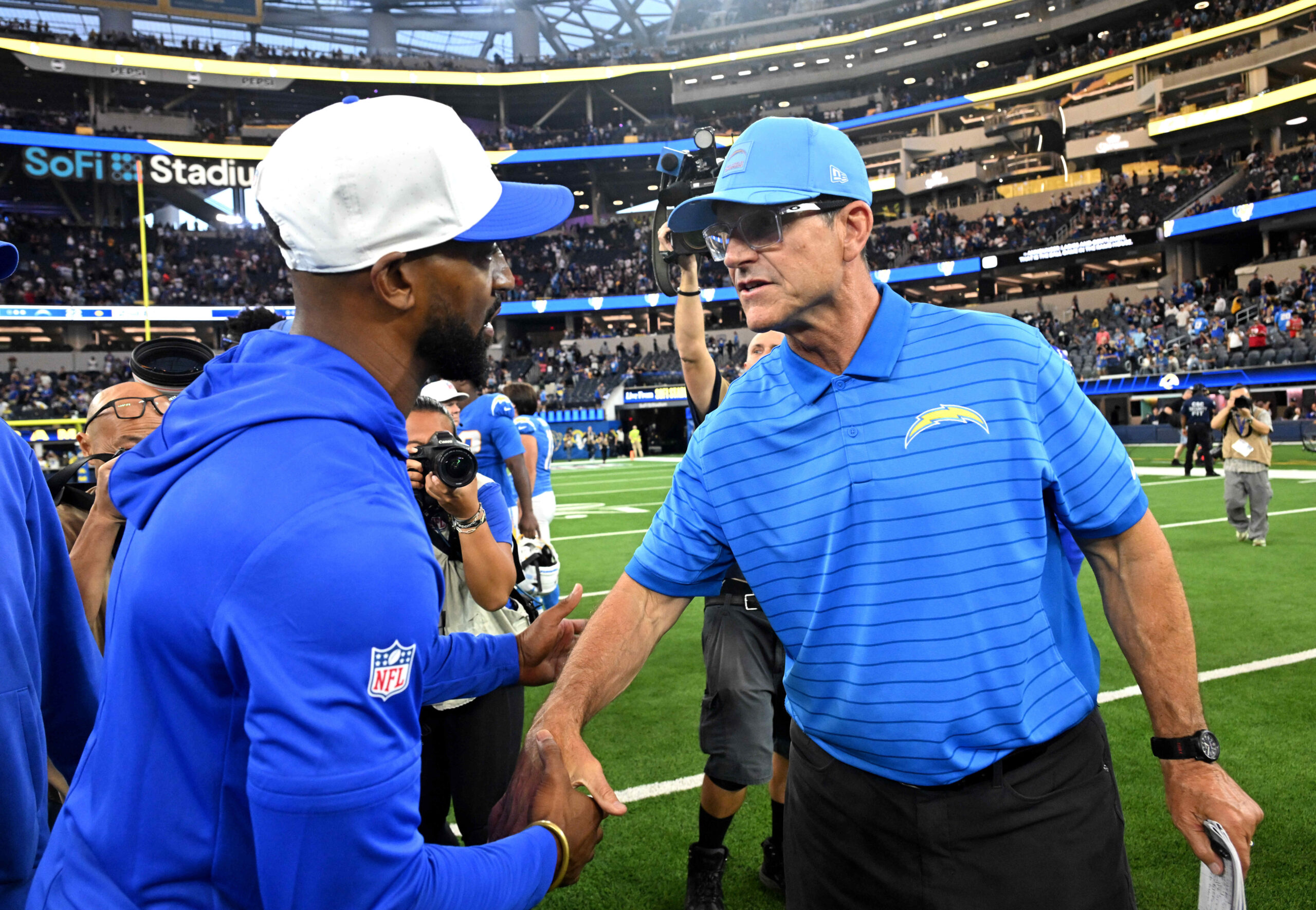 Aubrey Pleasant, left, Assistant Head Coach/Pass Game Coordinator shakes hands...