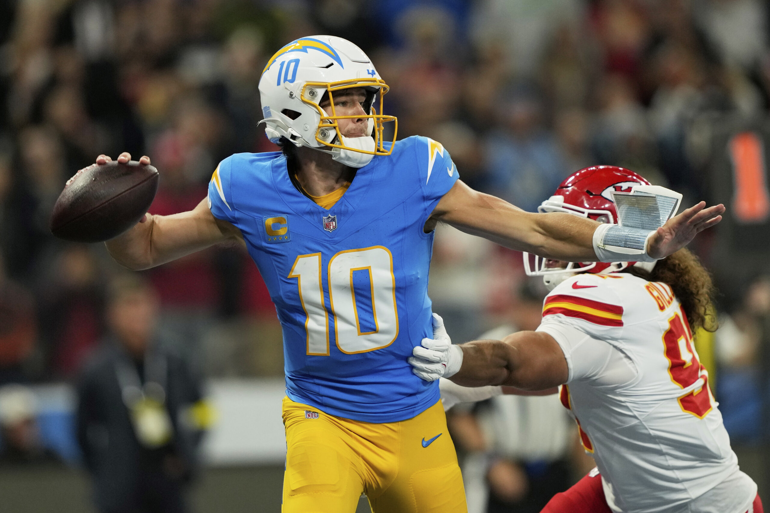 Chargers quarterback Justin Herbert looks to pass while under pressure...