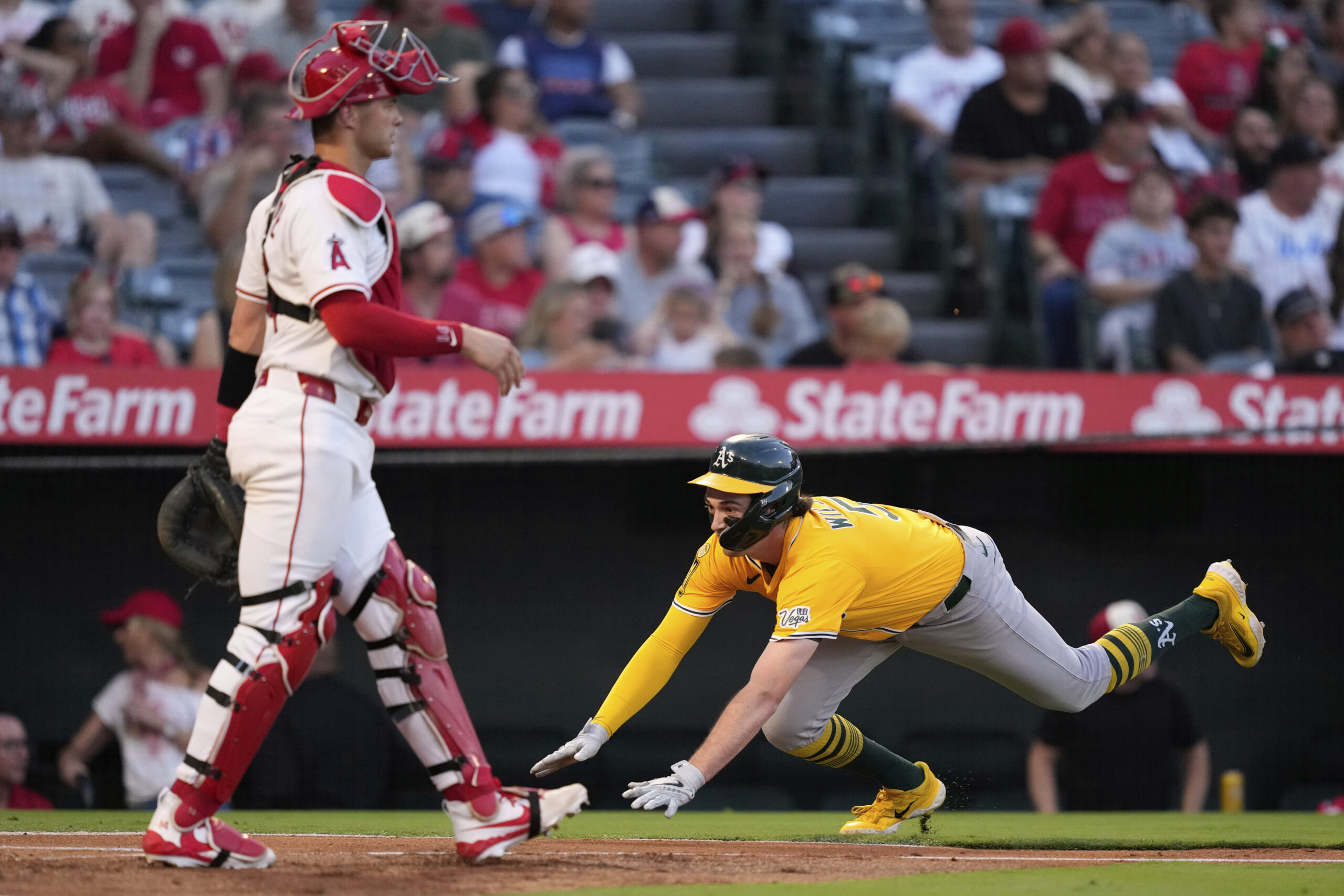 Athletics’ Jacob Wilson, right, scores on a double by Tyler...