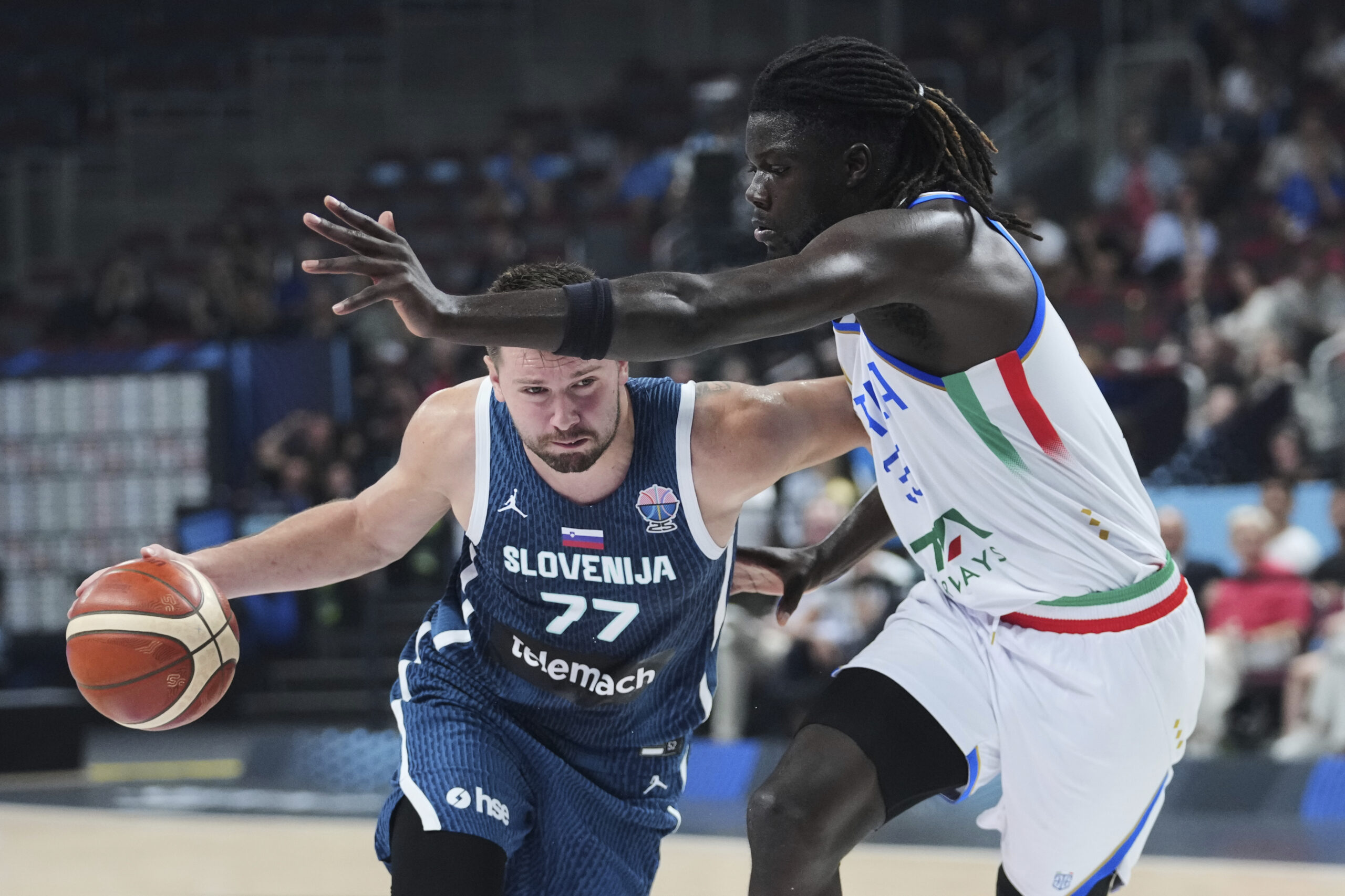 Slovenia’s Luka Doncic, left, drives as Italy’s Mouhamet Diouf defends...