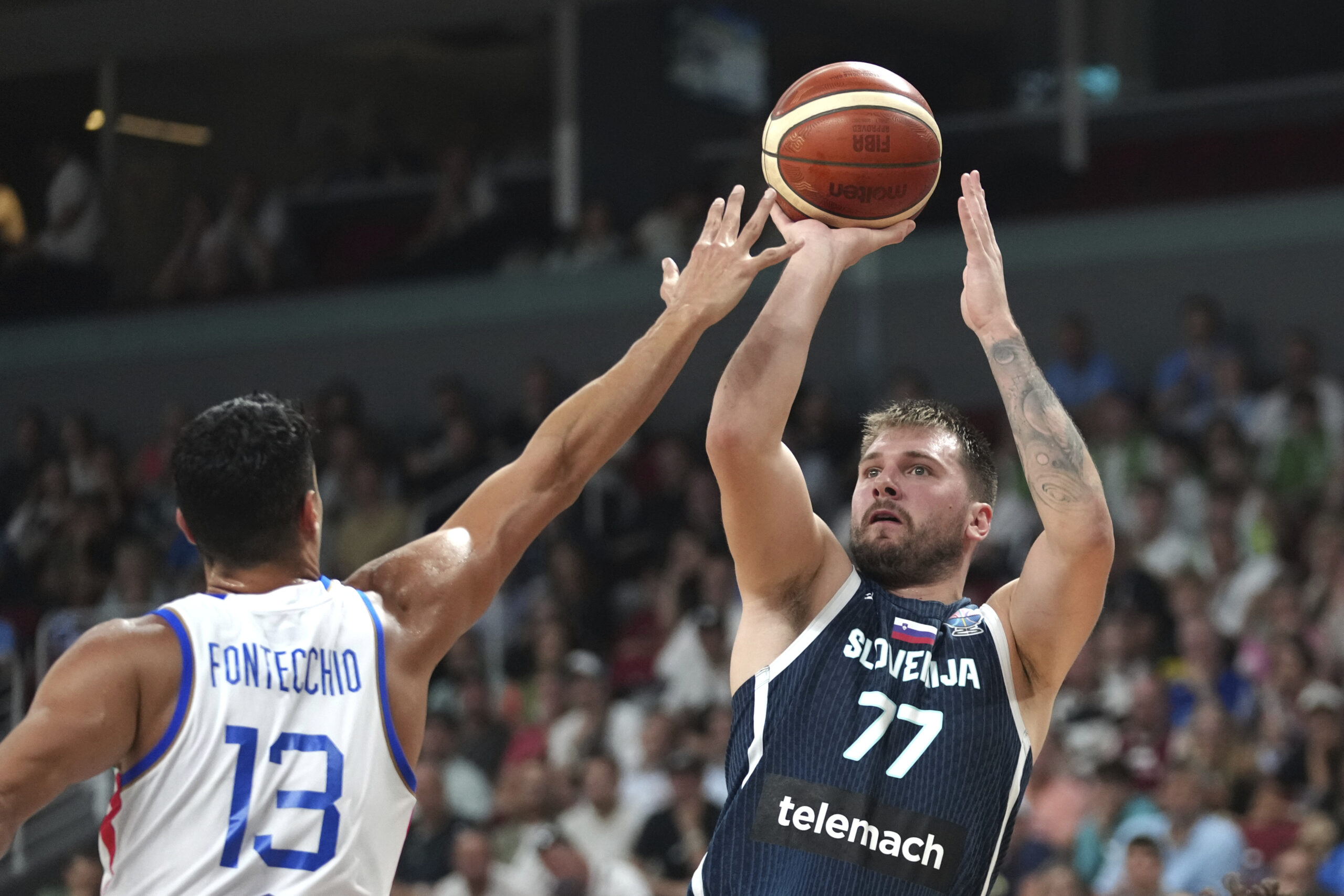 Slovenia’s Luka Doncic tries to shoot while defended by Italy’s...