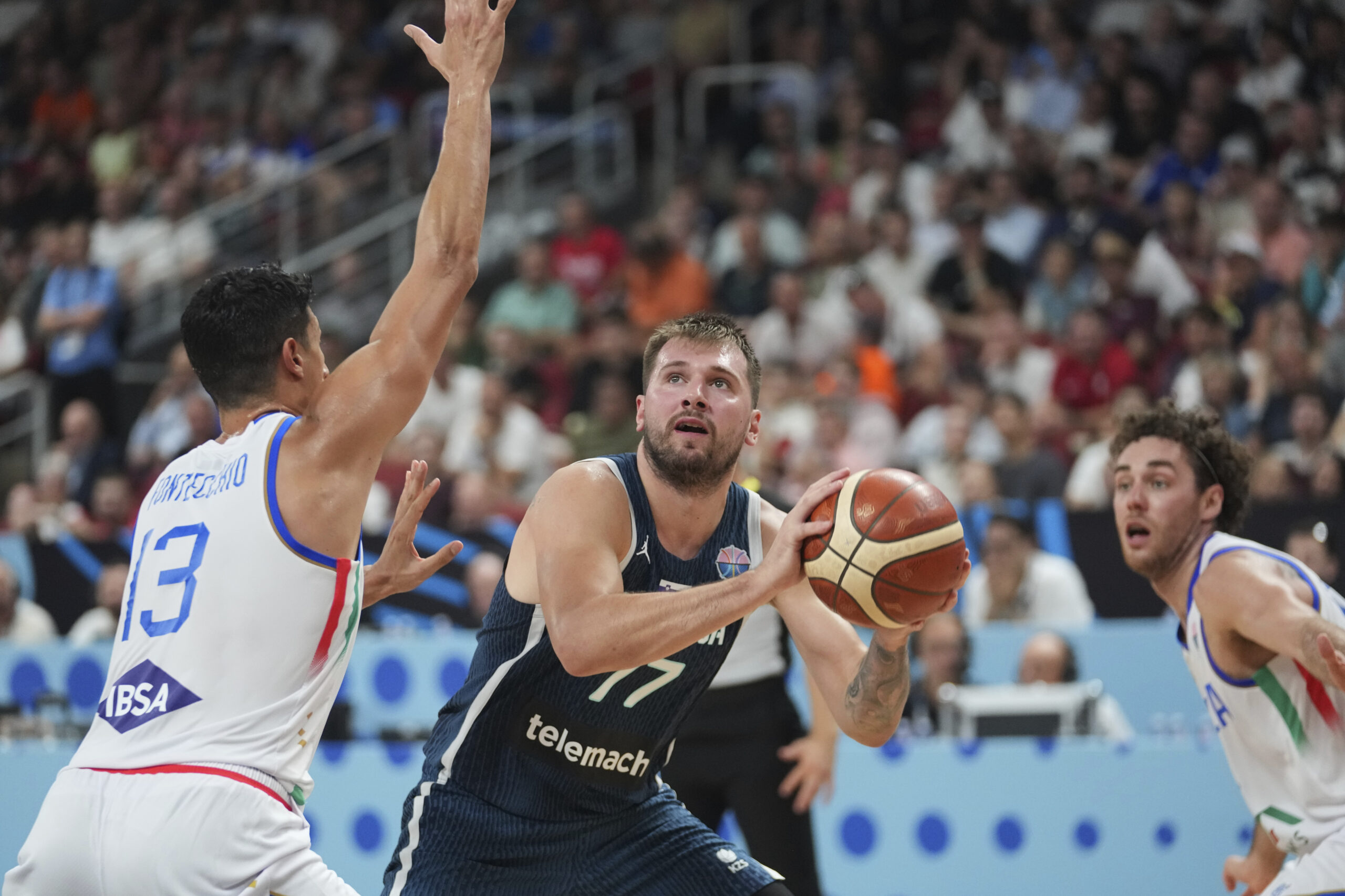 Slovenia’s Luka Doncic looks to shoot while defended by Italy’s...