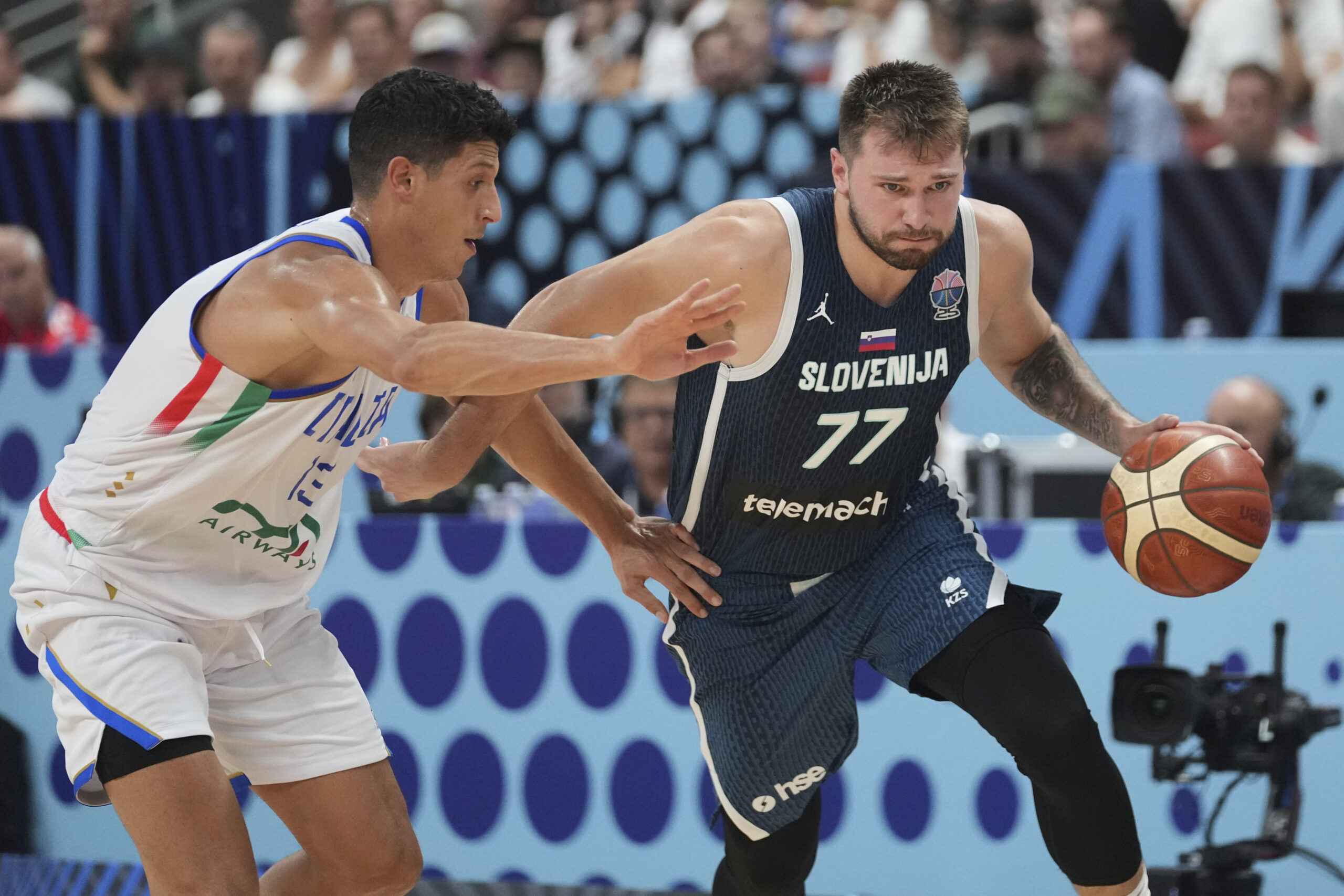 Italy’s Simone Fontecchio, left, tries to defend Slovenia’s Luka Doncic...