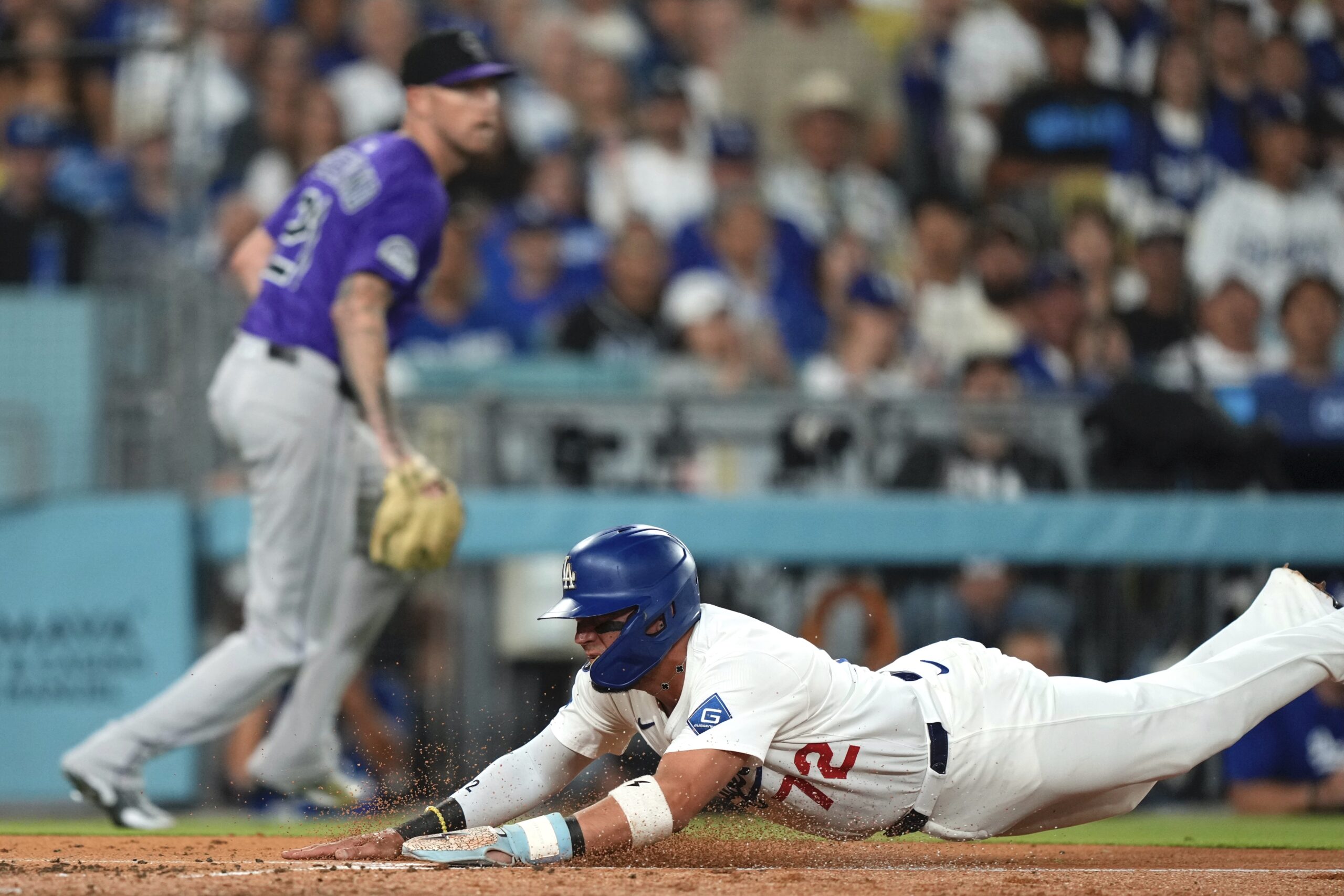 The Dodgers’ Miguel Rojas, right, scores on sacrifice fly by...