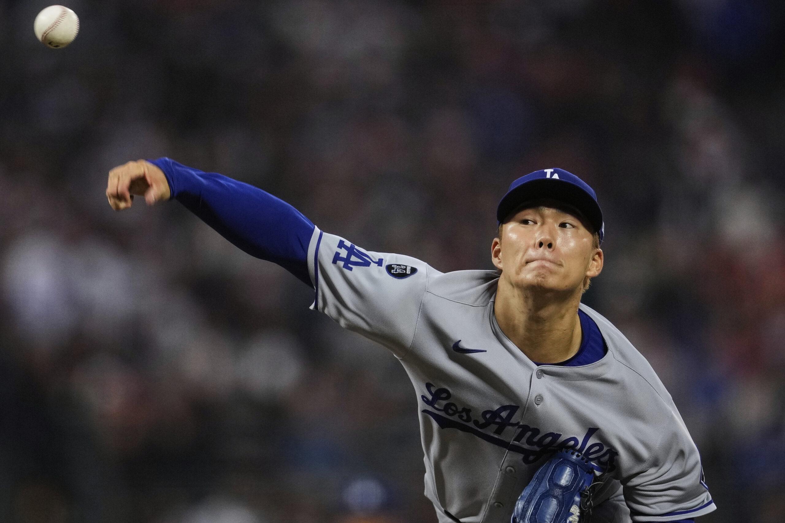 Dodgers starting pitcher Yoshinobu Yamamoto throws to the plate during...