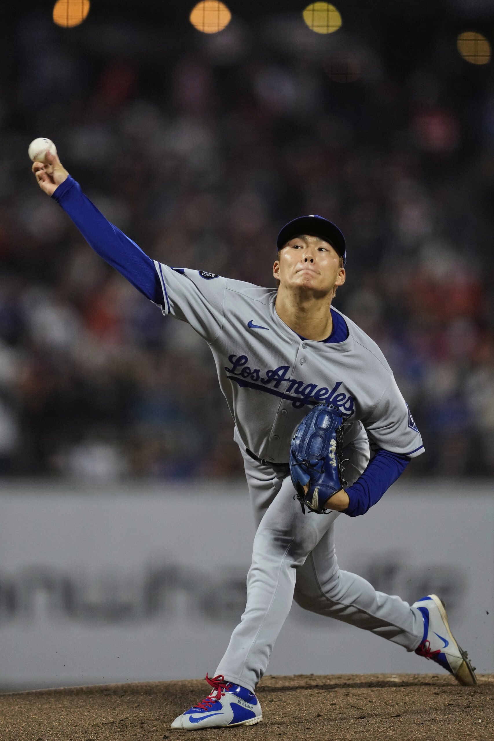 Dodgers starting pitcher Yoshinobu Yamamoto throws to the plate during...
