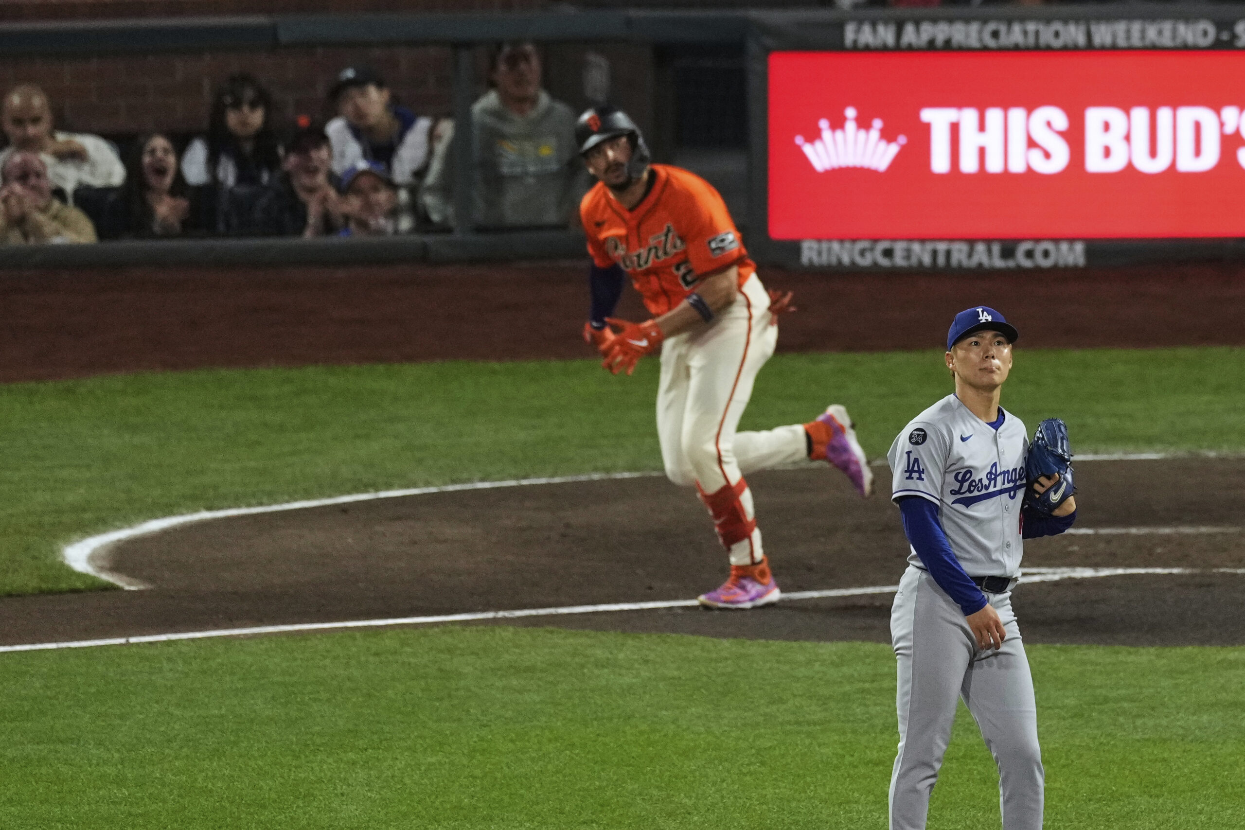 Dodgers starting pitcher Yoshinobu Yamamoto, right, watches the flight of...
