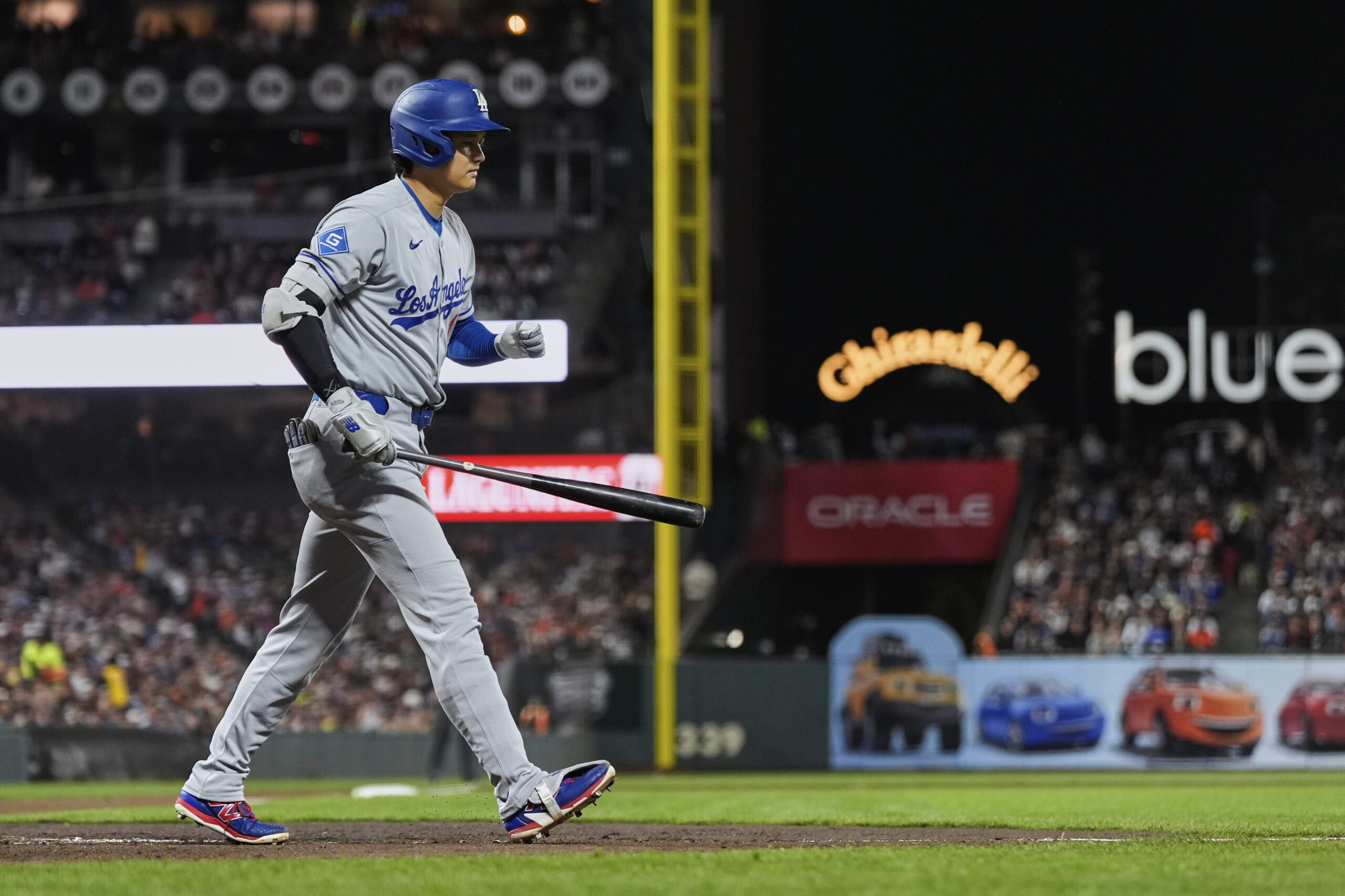 Dodgers star Shohei Ohtani makes his way to first base...