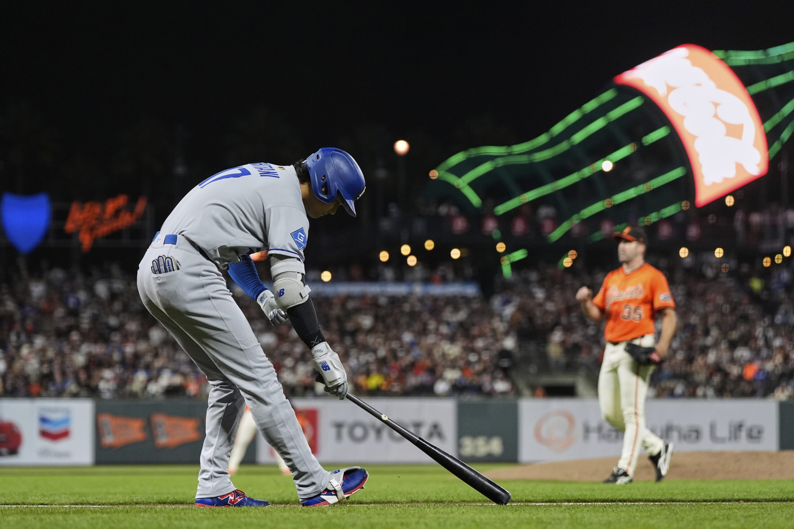 Dodgers star Shohei Ohtani, left, makes his way to first...