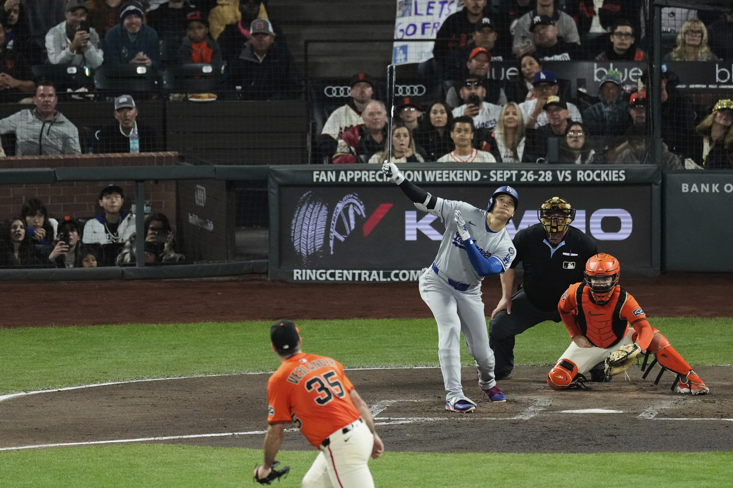Dodgers star Shohei Ohtani, center, watches his fly ball out...