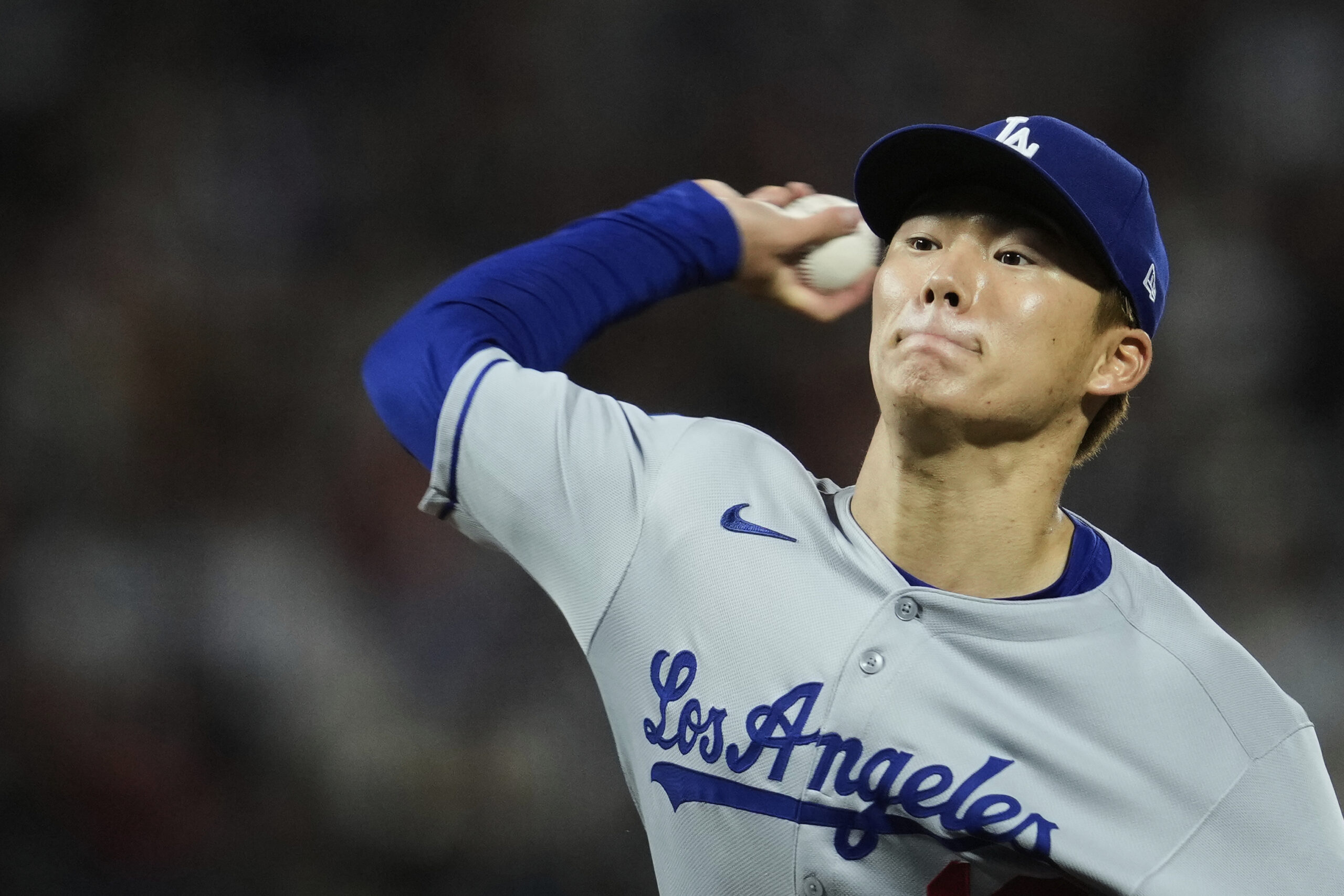 Dodgers starting pitcher Yoshinobu Yamamoto throws to the plate during...