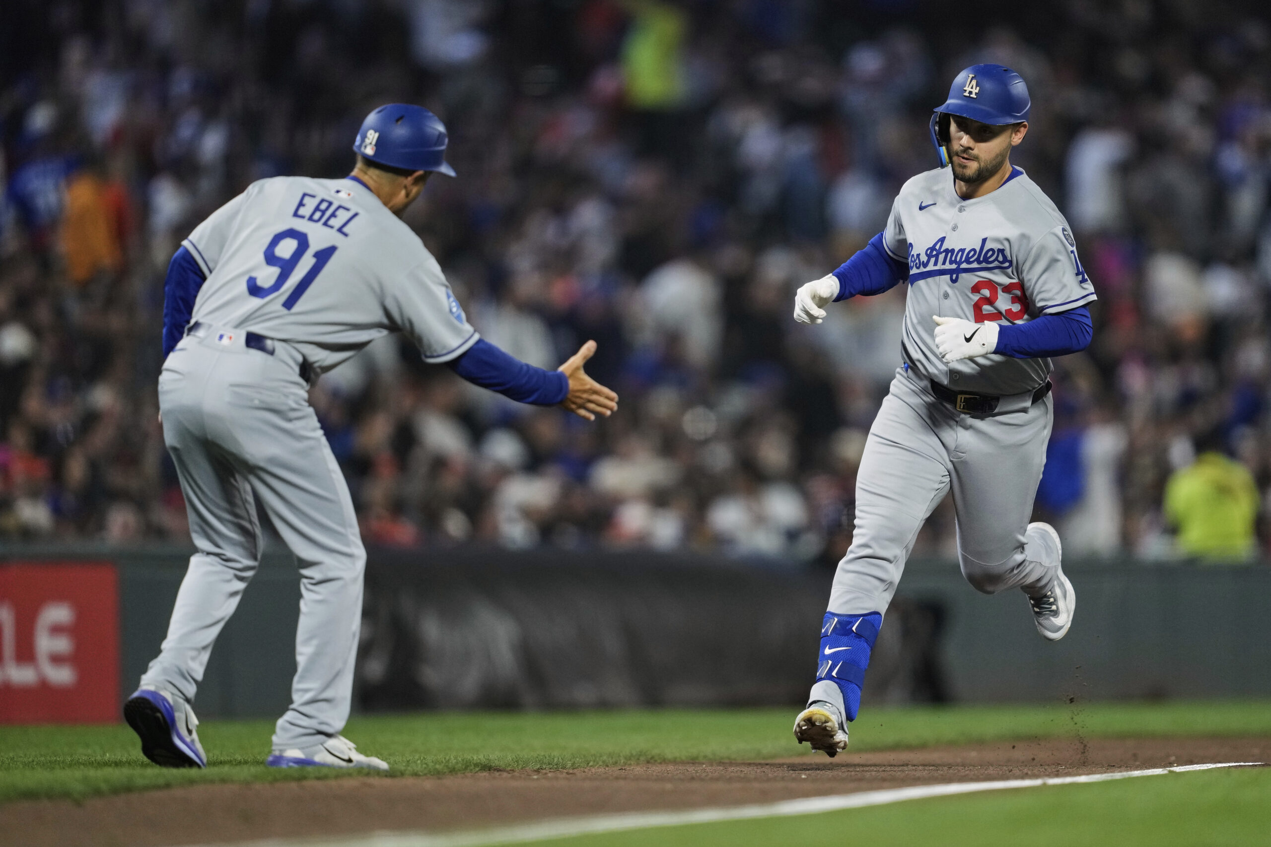 The Dodgers’ Michael Conforto, right, celebrates with third base coach...