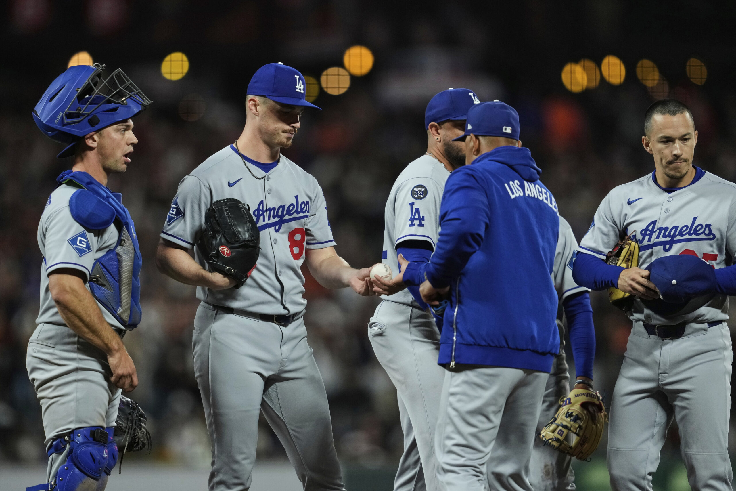 Dodgers relief pitcher Jack Dreyer, second from left, hands the...