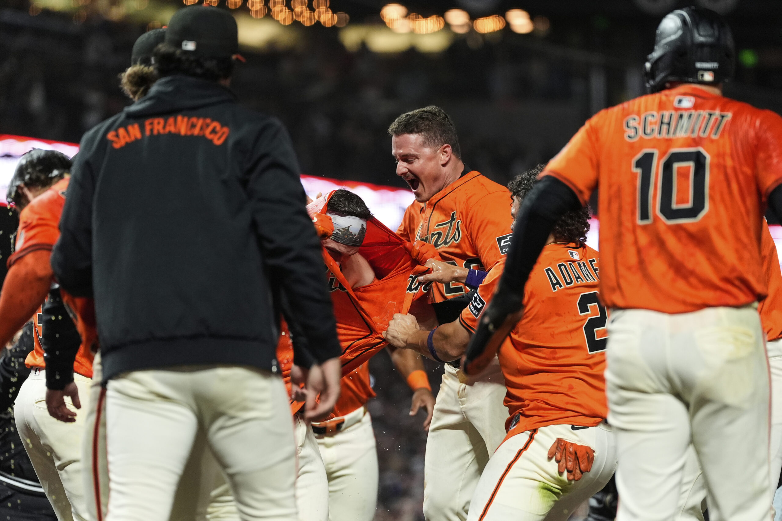 The San Francisco Giants’ Patrick Bailey, center left, is mobbed...