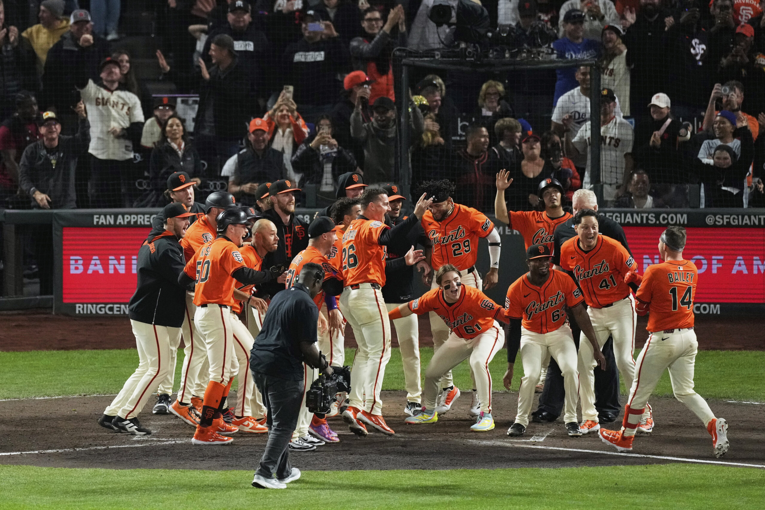 The San Francisco Giants’ Patrick Bailey (14) is mobbed by...