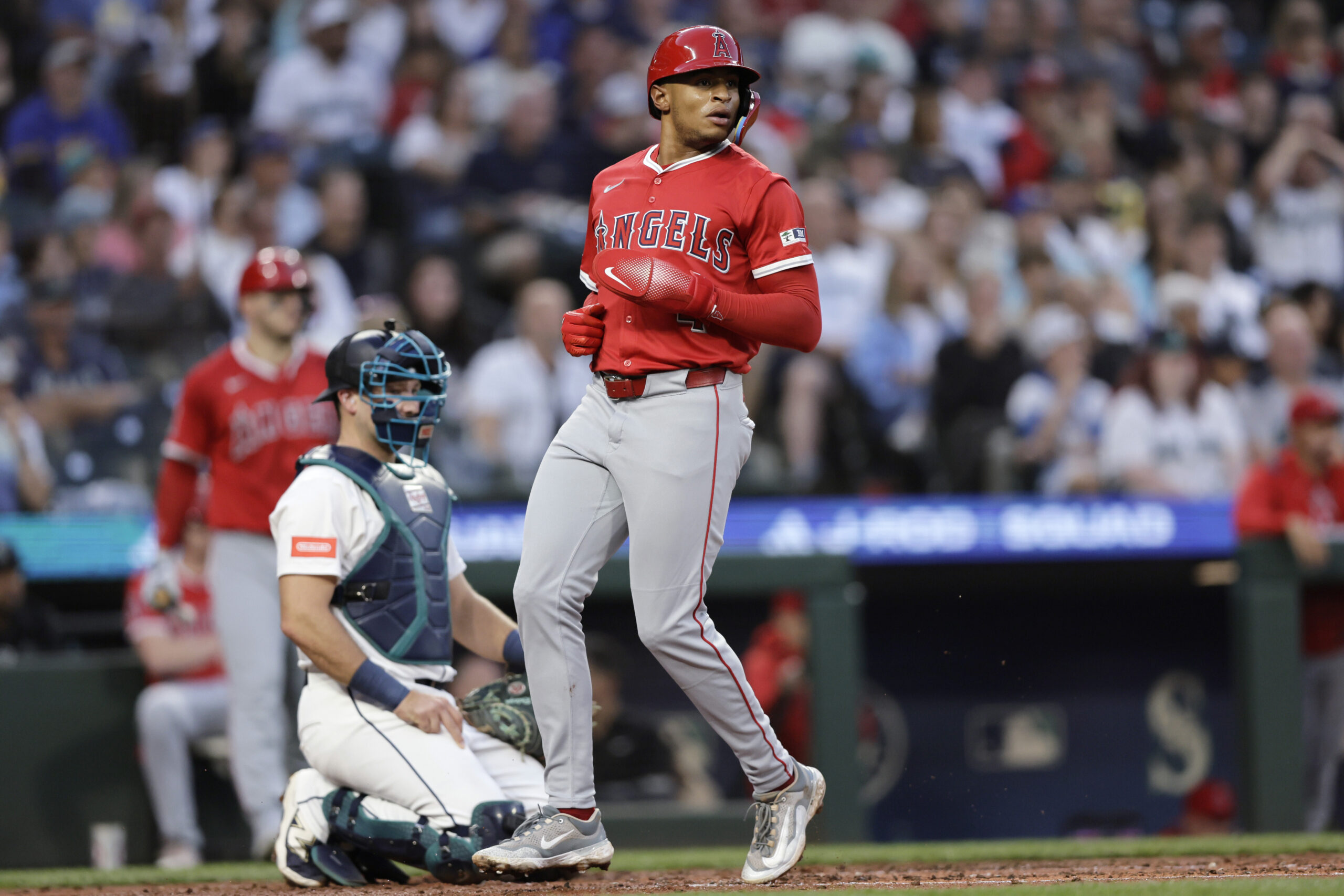 Angels’ Christian Moore scores as Seattle Mariners catcher Cal Raleigh...