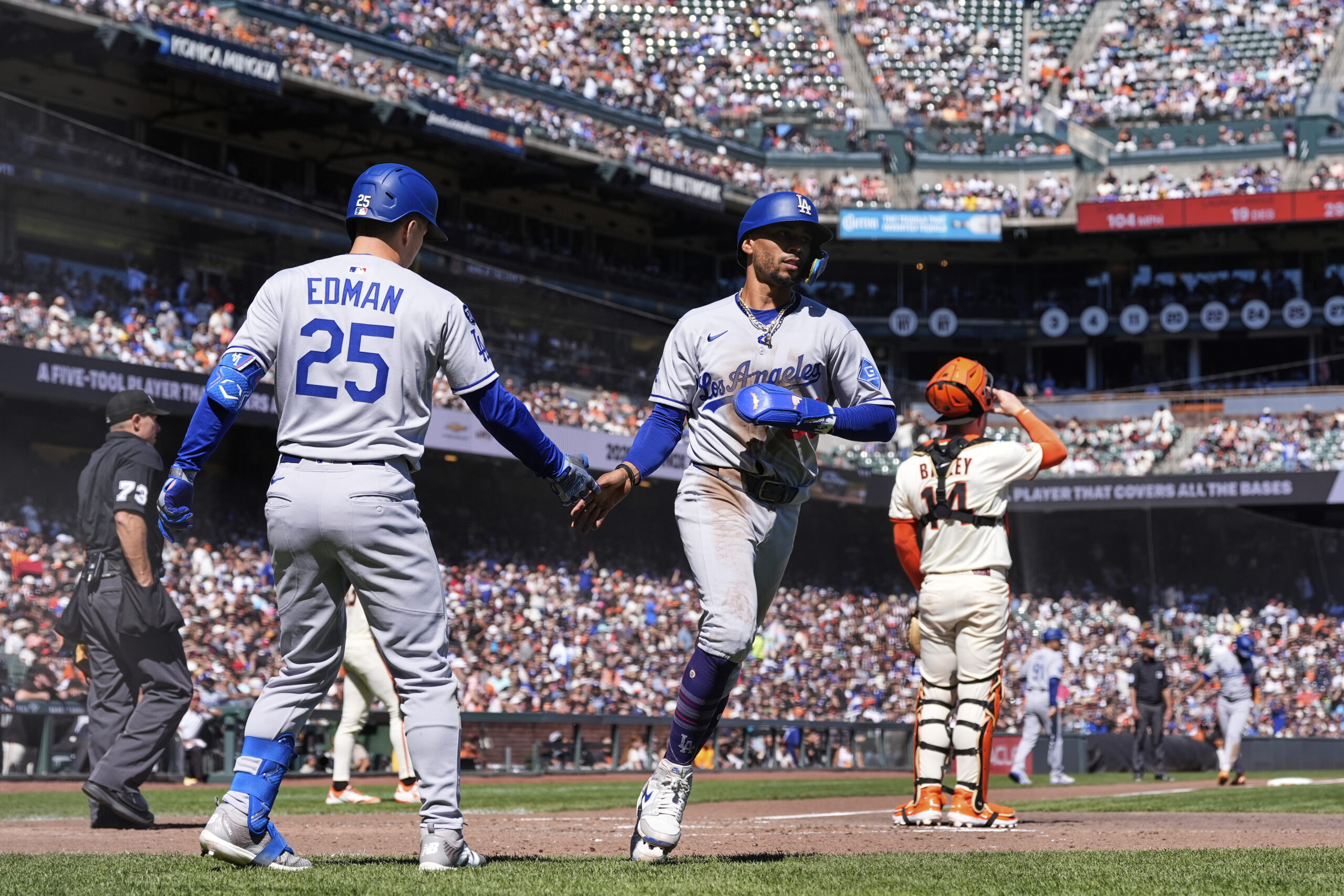 Dodgers’ Mookie Betts, center, celebrates both Tommy Edman (25) after...