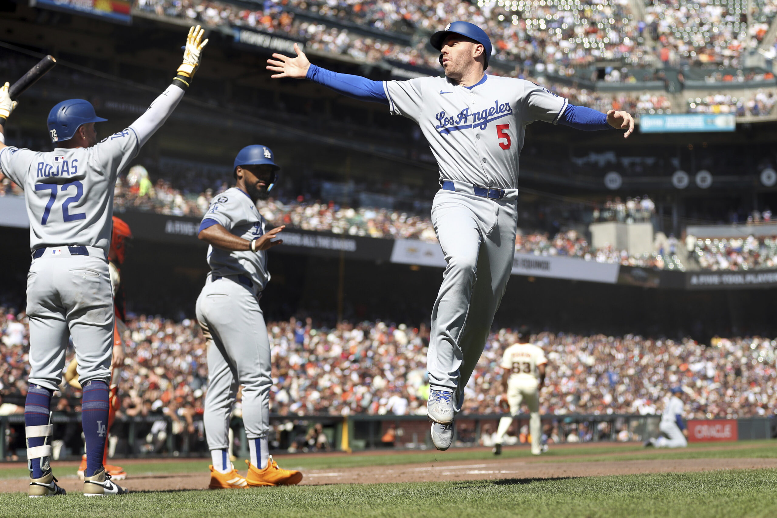 Dodgers’ Freddie Freeman (5) tries to high-five Miguel Rojas (72)...