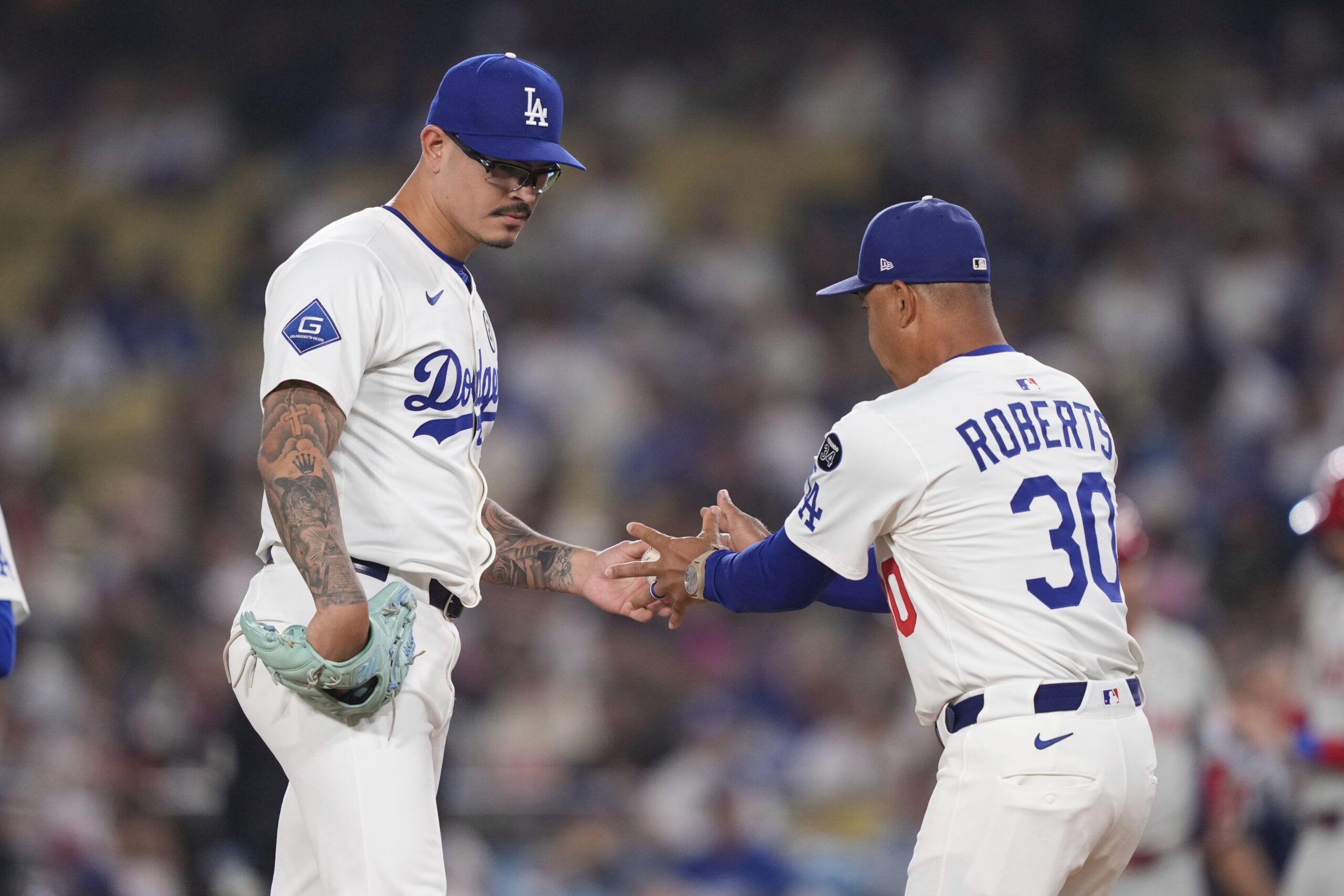 Dodgers opening pitcher Anthony Banda, left, hands the ball to...