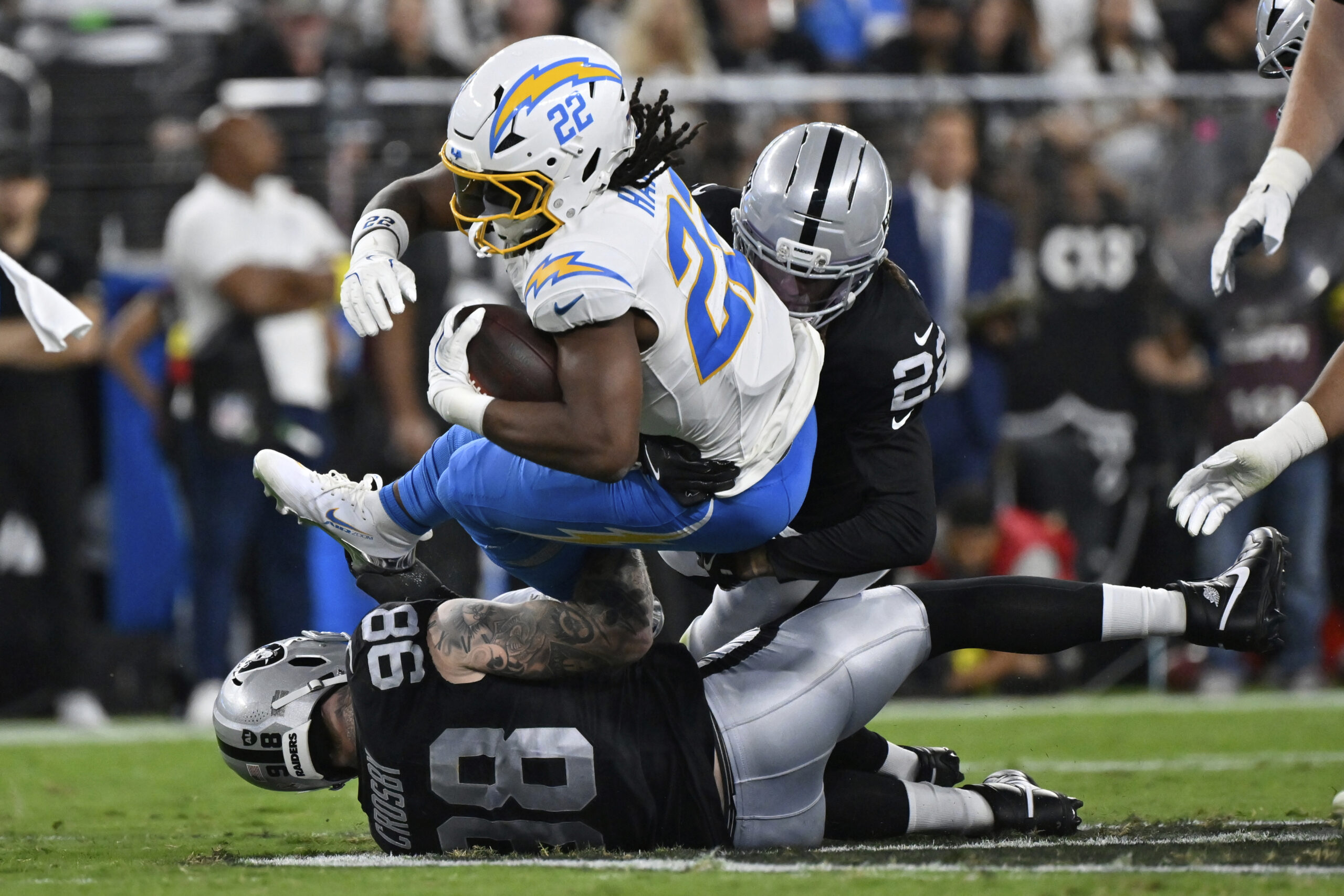 Chargers running back Najee Harris (22) is tackled by Las...