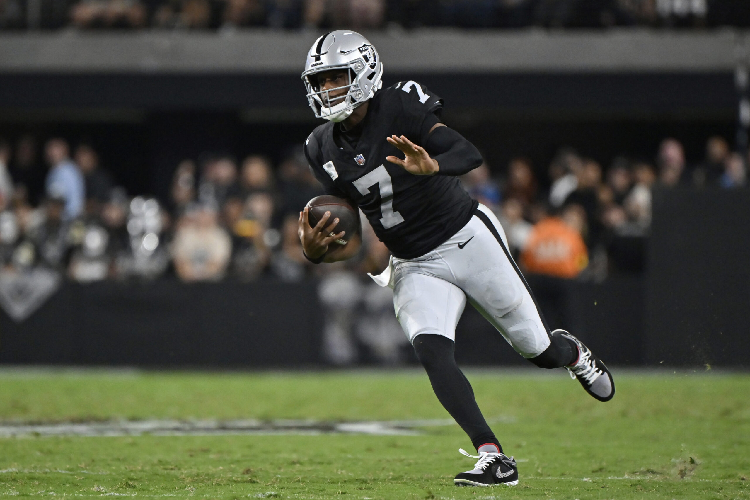 Las Vegas Raiders quarterback Geno Smith runs with the ball...