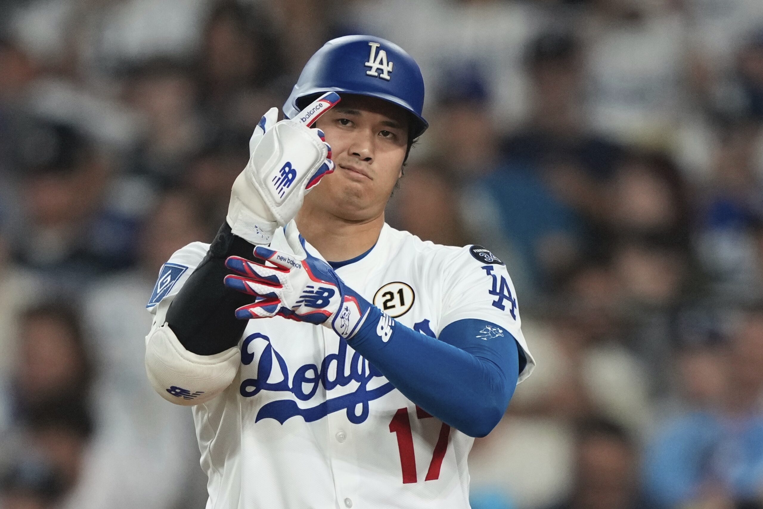 Dodgers star Shohei Ohtani adjusts his gloves during his at-bat...