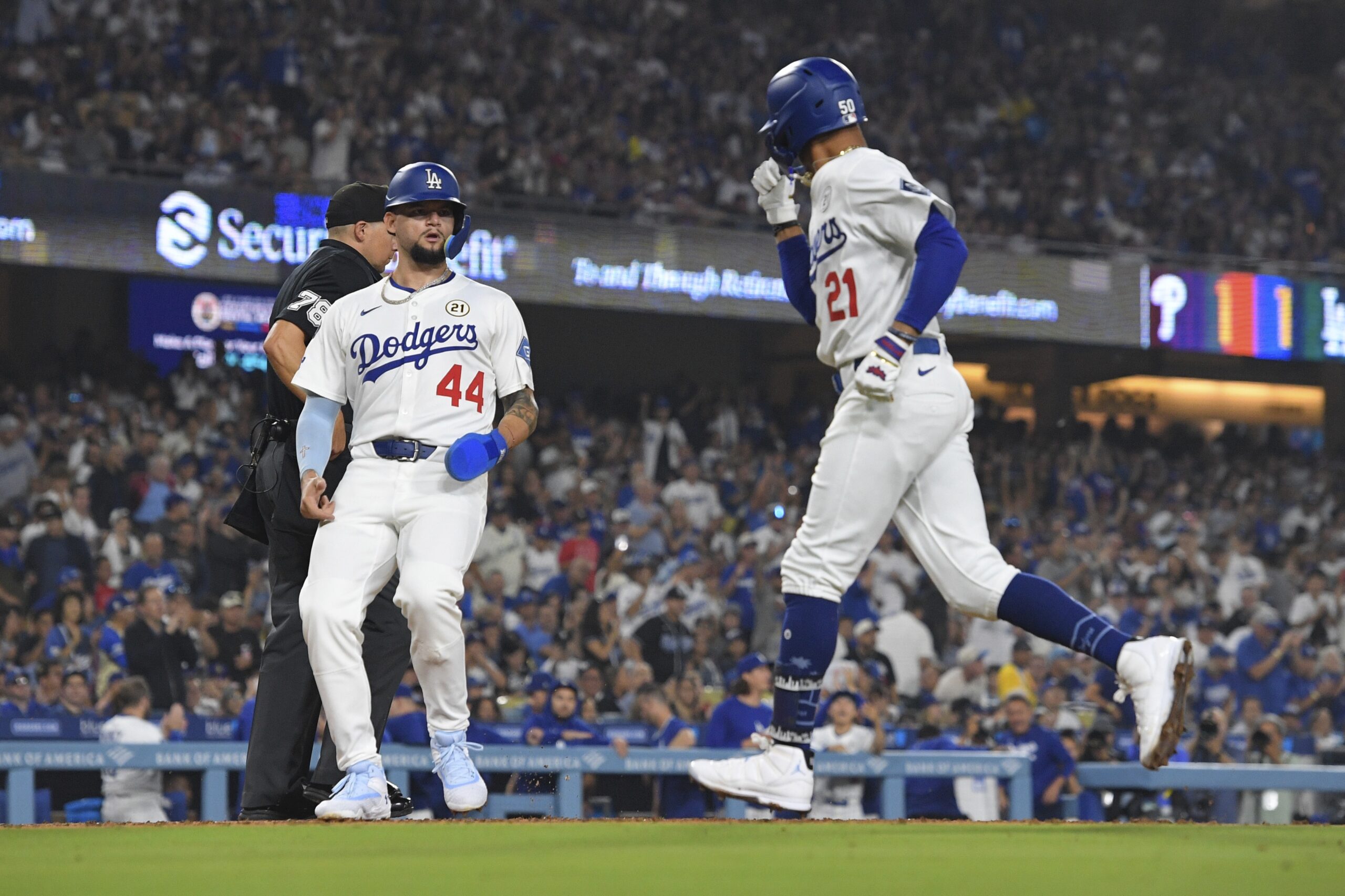 The Dodgers’ Andy Pages, left, scores on a sacrifice by...