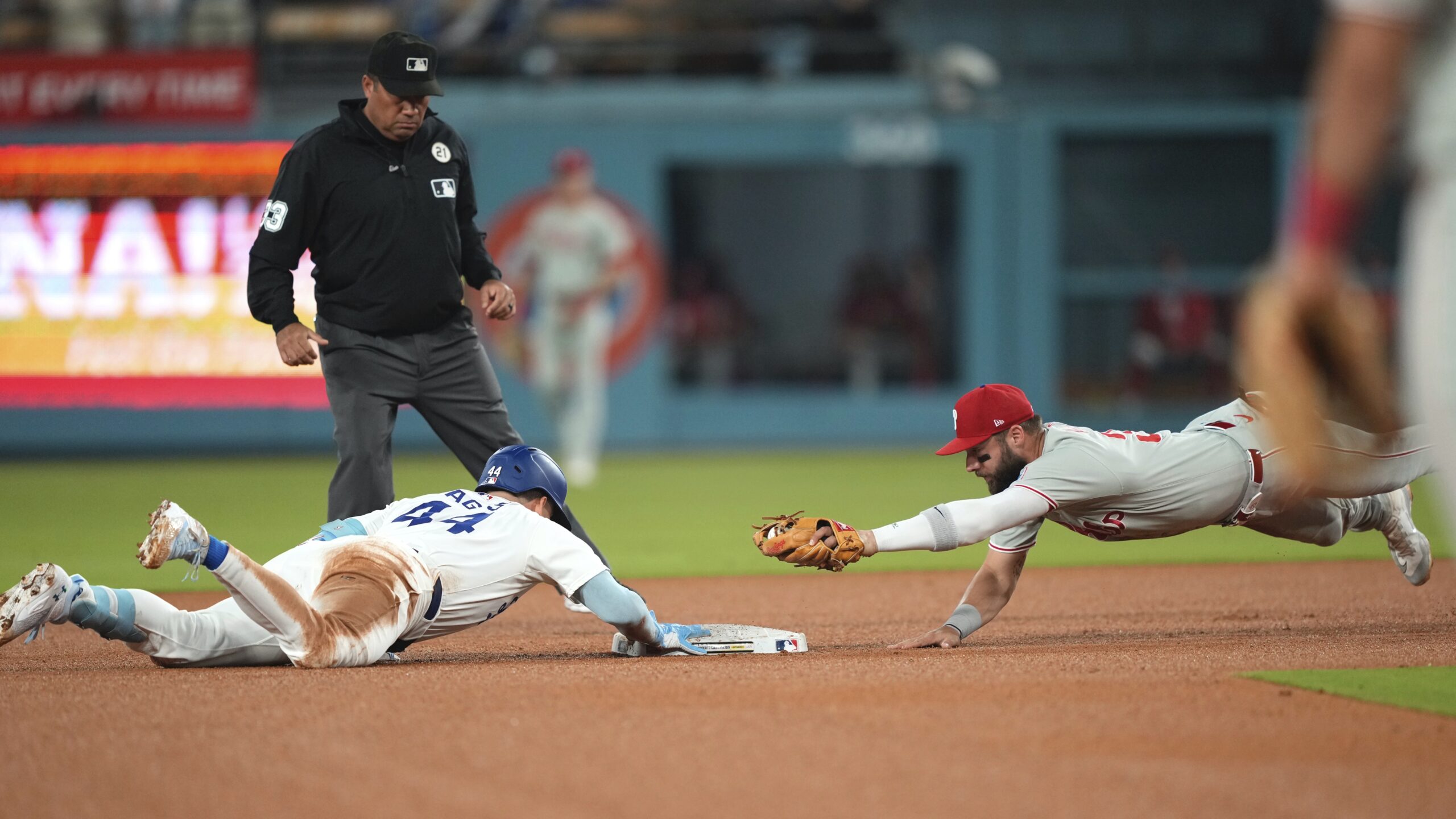 The Dodgers’ Andy Pages, left, dives back to second base...