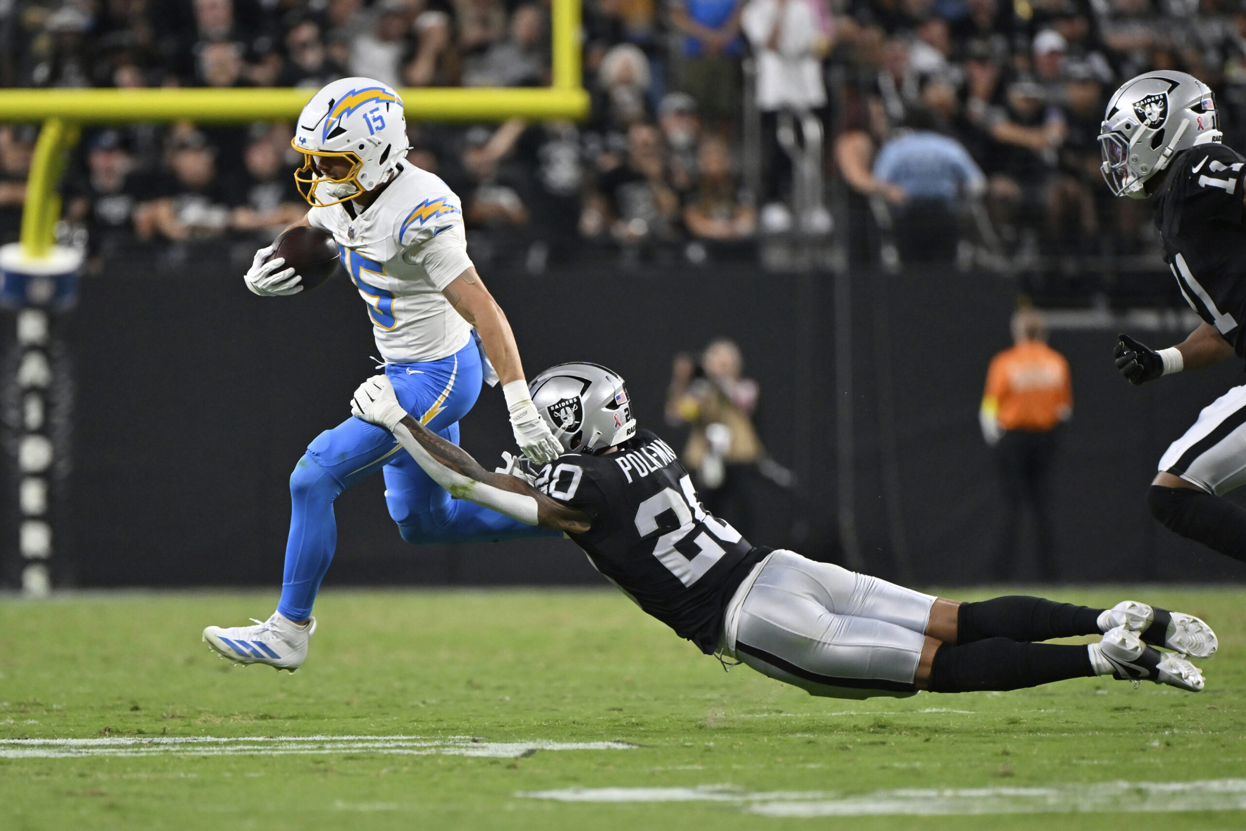 Chargers wide receiver Ladd McConkey, left, breaks a tackle by...