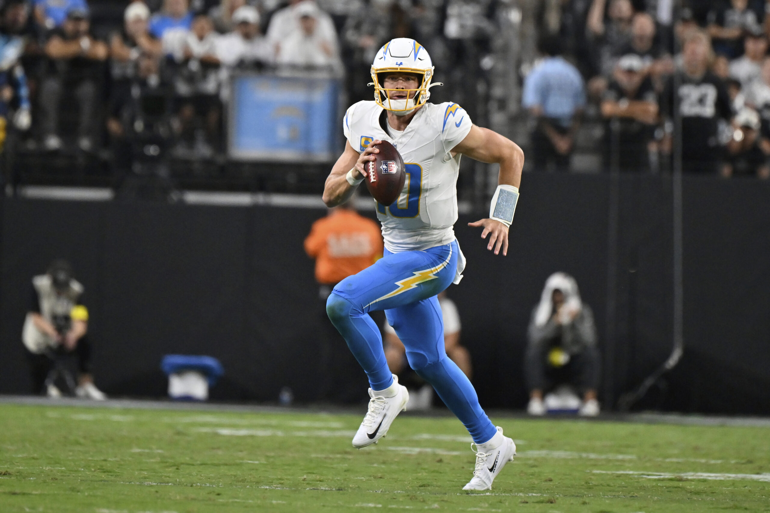 Chargers quarterback Justin Herbert runs with the ball against the...