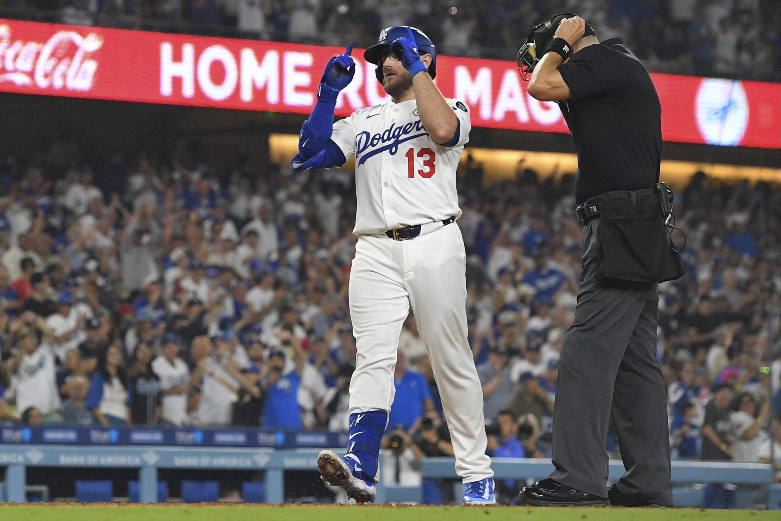 The Dodgers’ Max Muncy gestures as he scores after hitting...
