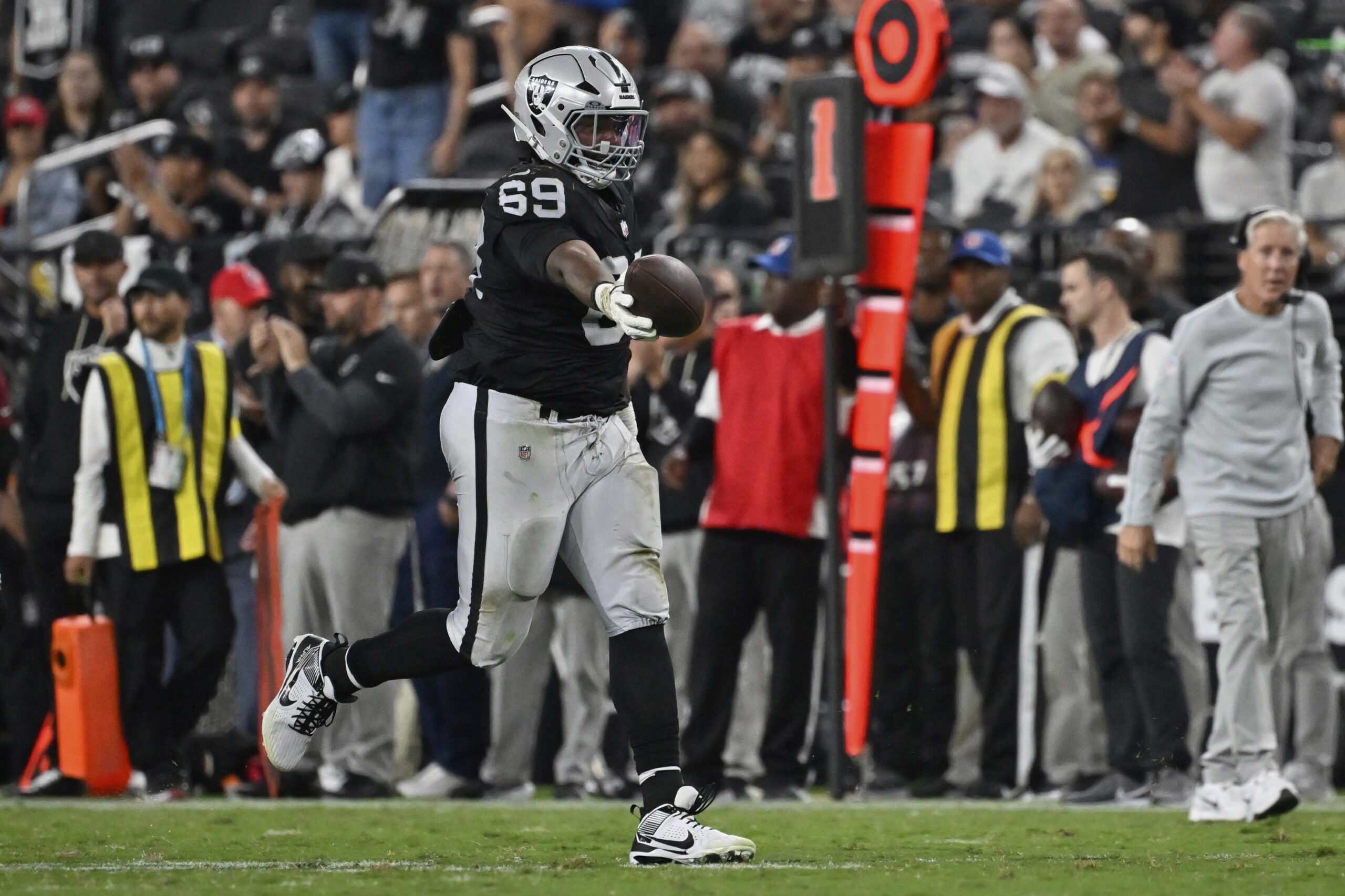 Las Vegas Raiders defensive tackle Adam Butler celebrates after making...