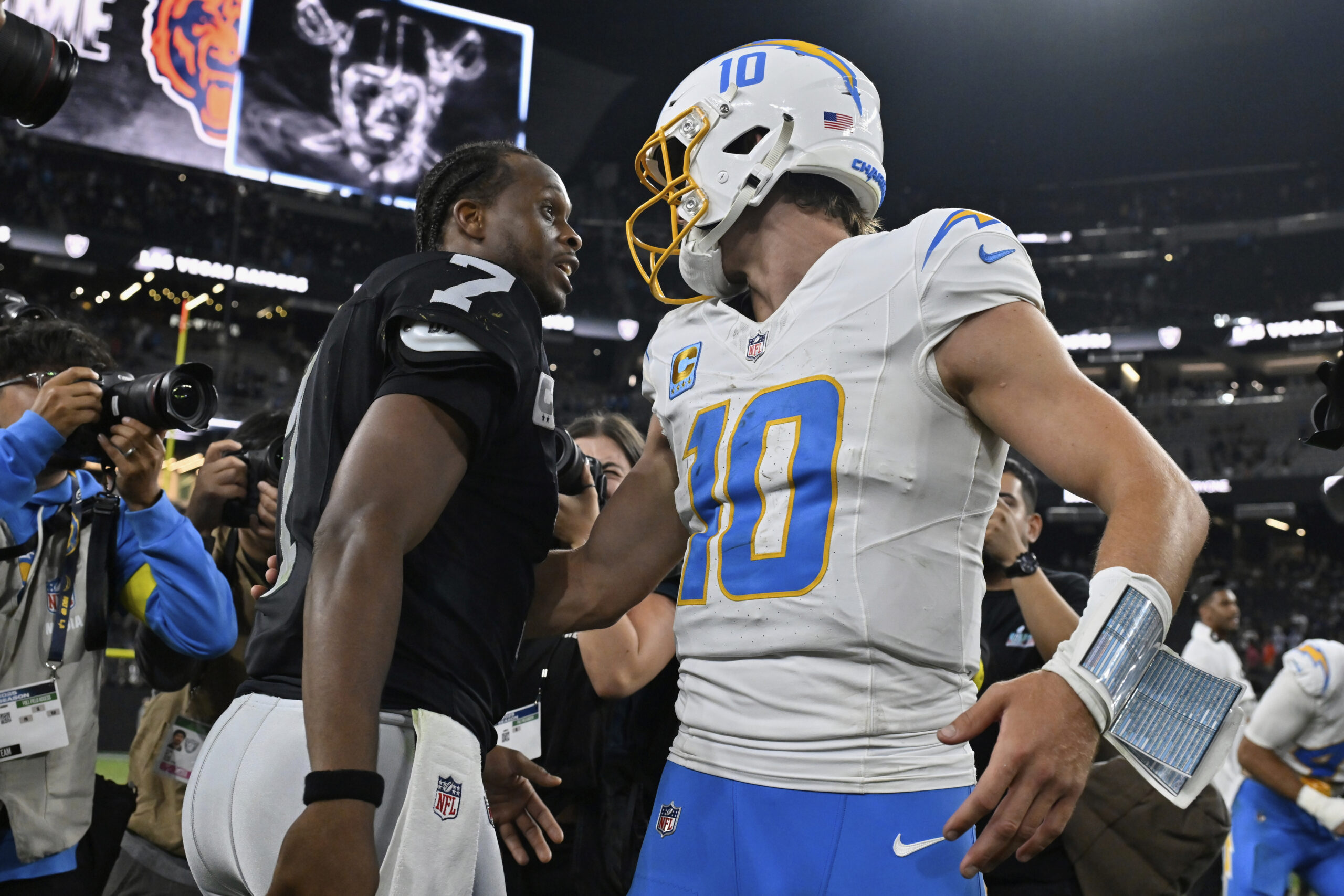 Las Vegas Raiders quarterback Geno Smith (7) and Chargers quarterback...