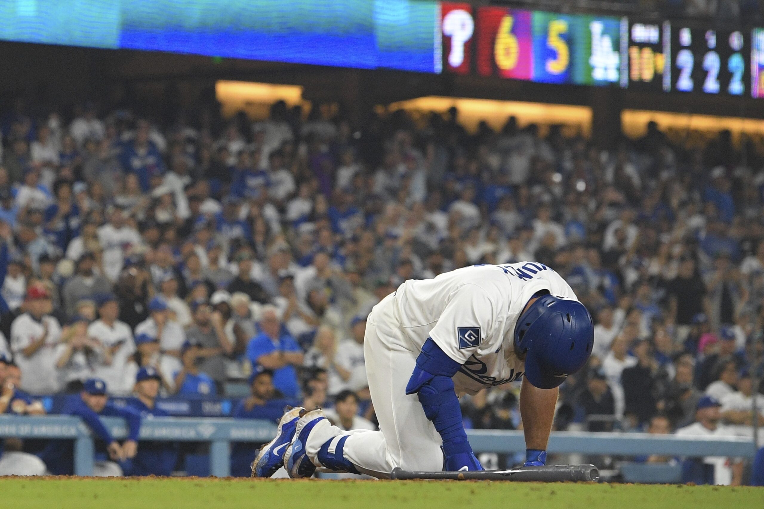 The Dodgers’ Max Muncy kneels on the ground after grounding...