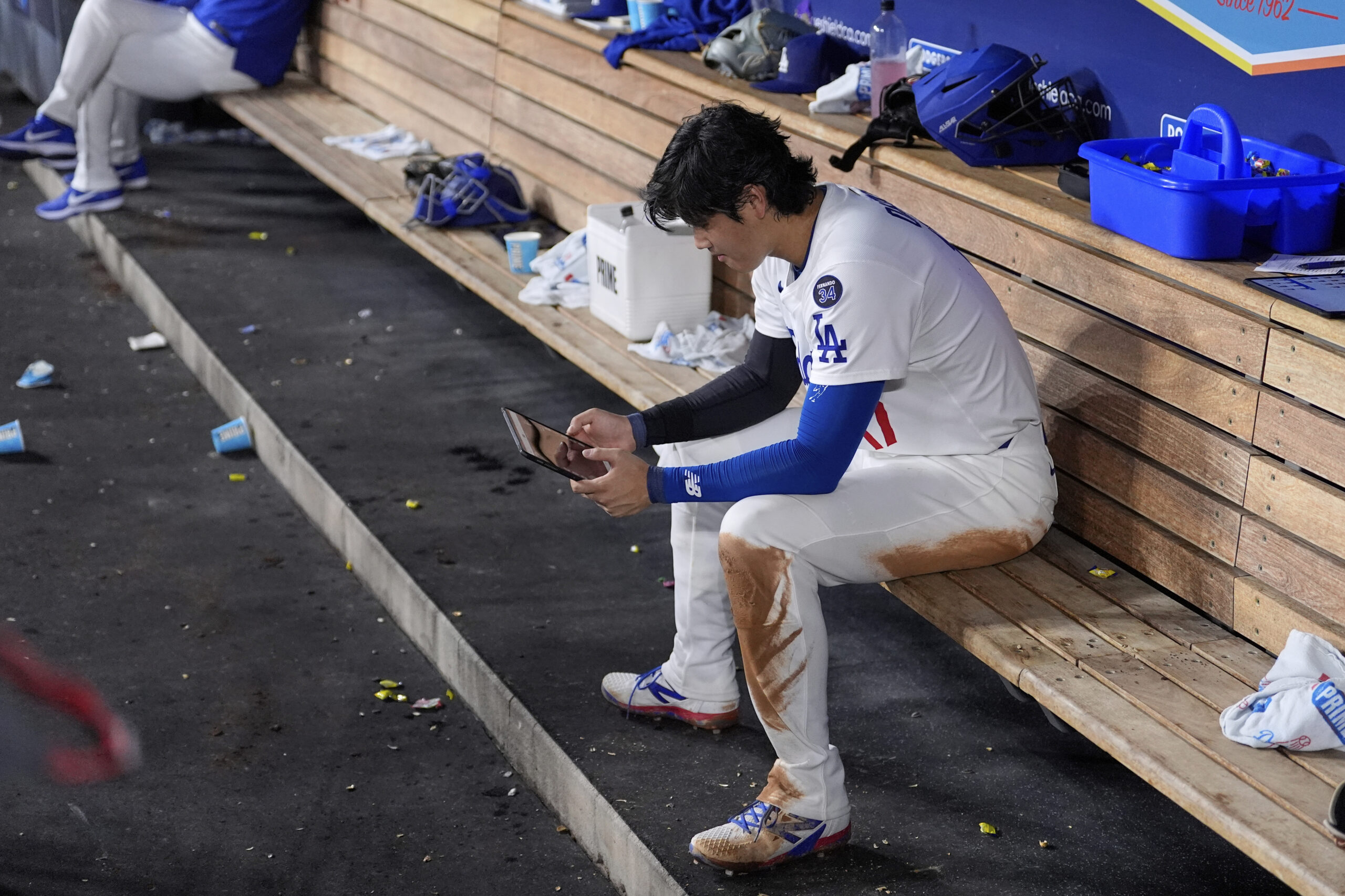 Dodgers star Shohei Ohtani looks at a tablet in the...