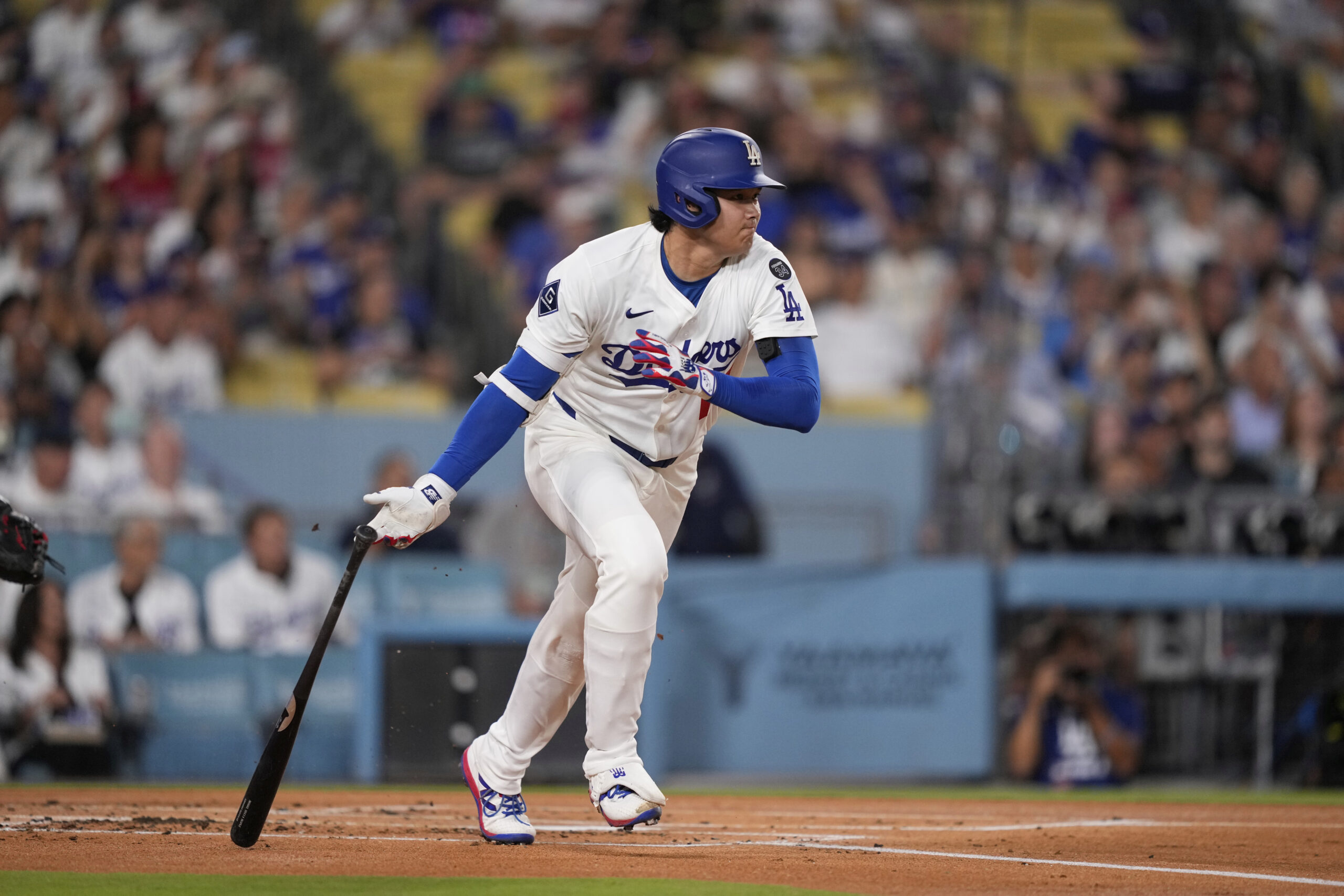 Dodgers star Shohei Ohtani watches his single during the first...