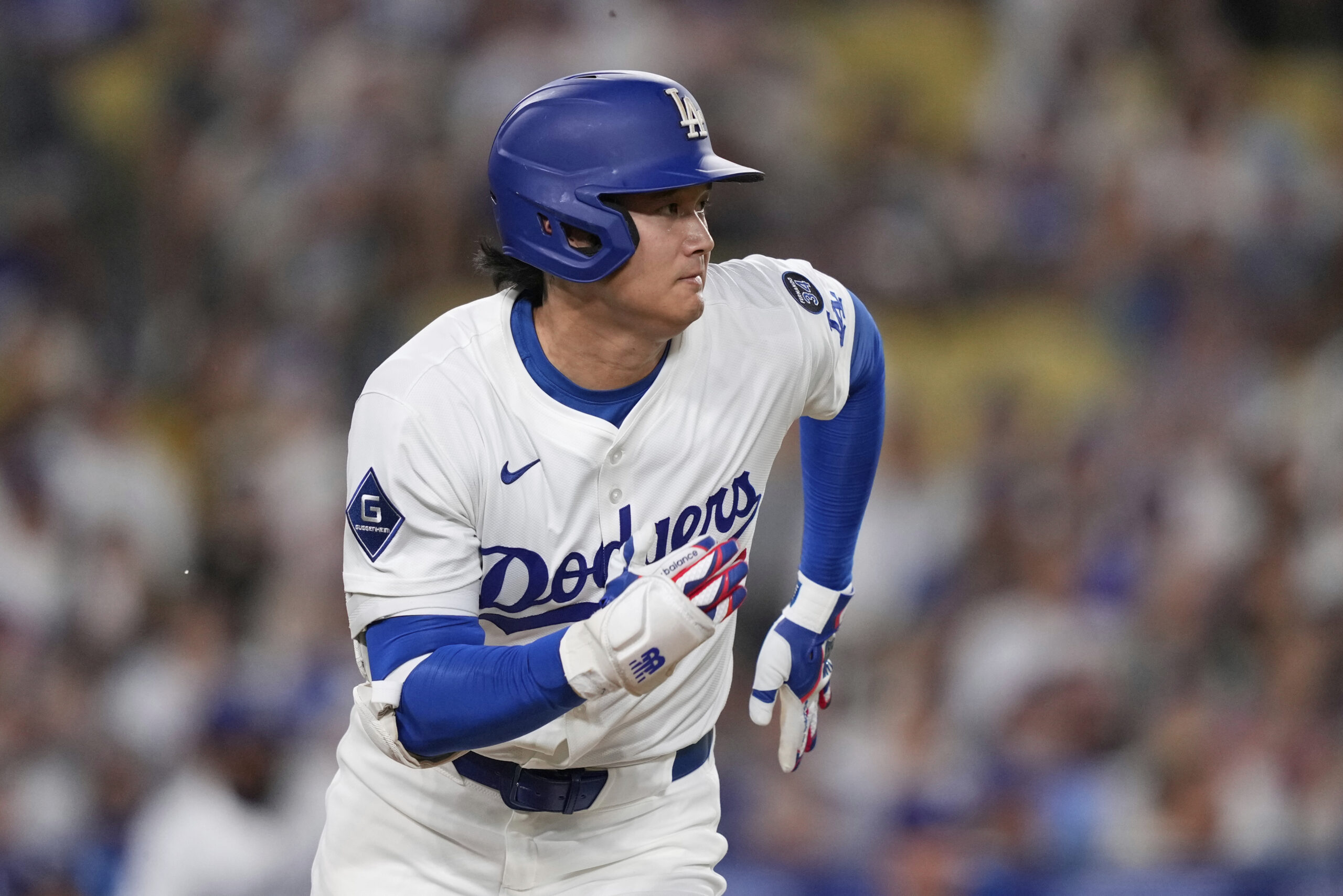 Dodgers star Shohei Ohtani watches his single during the first...
