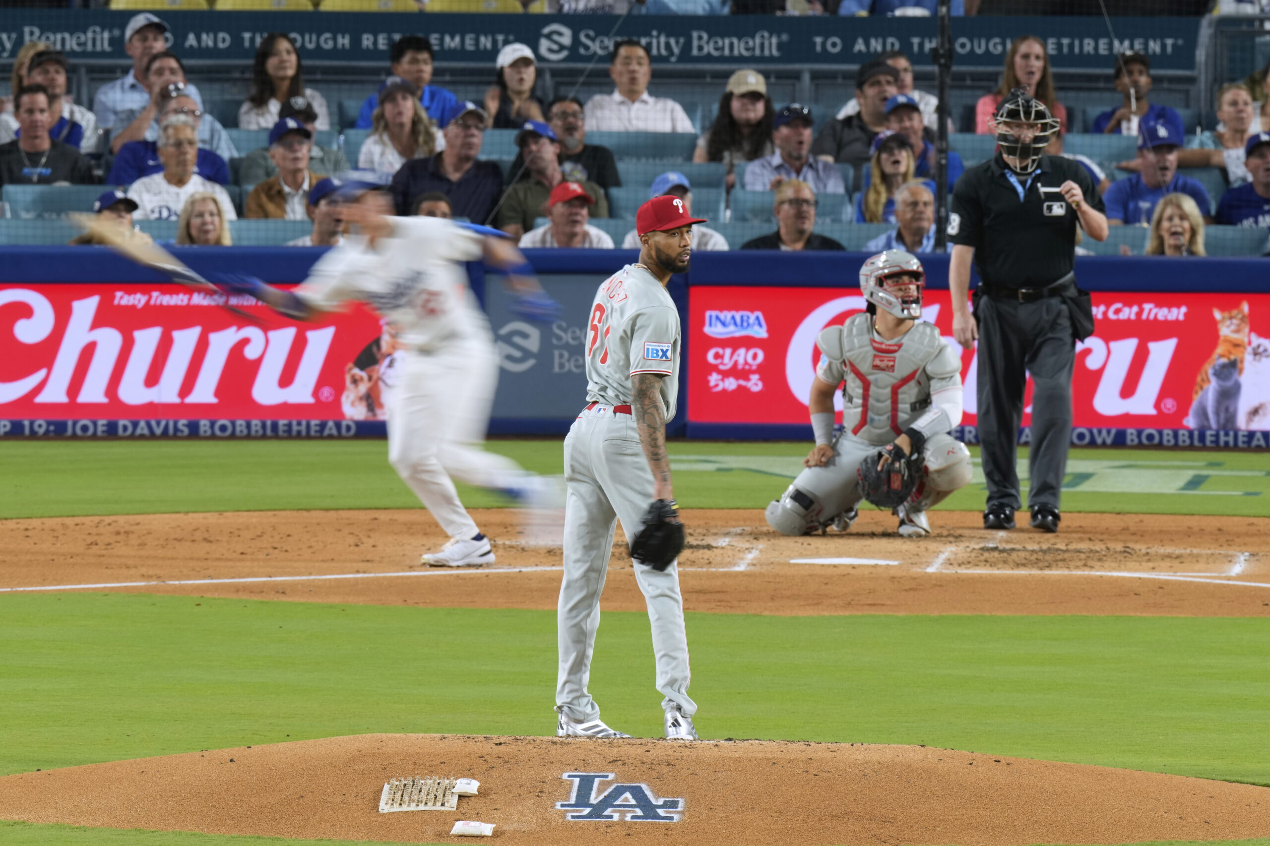 Philadelphia Phillies starting pitcher Cristopher Sanchez, center, looks to the...