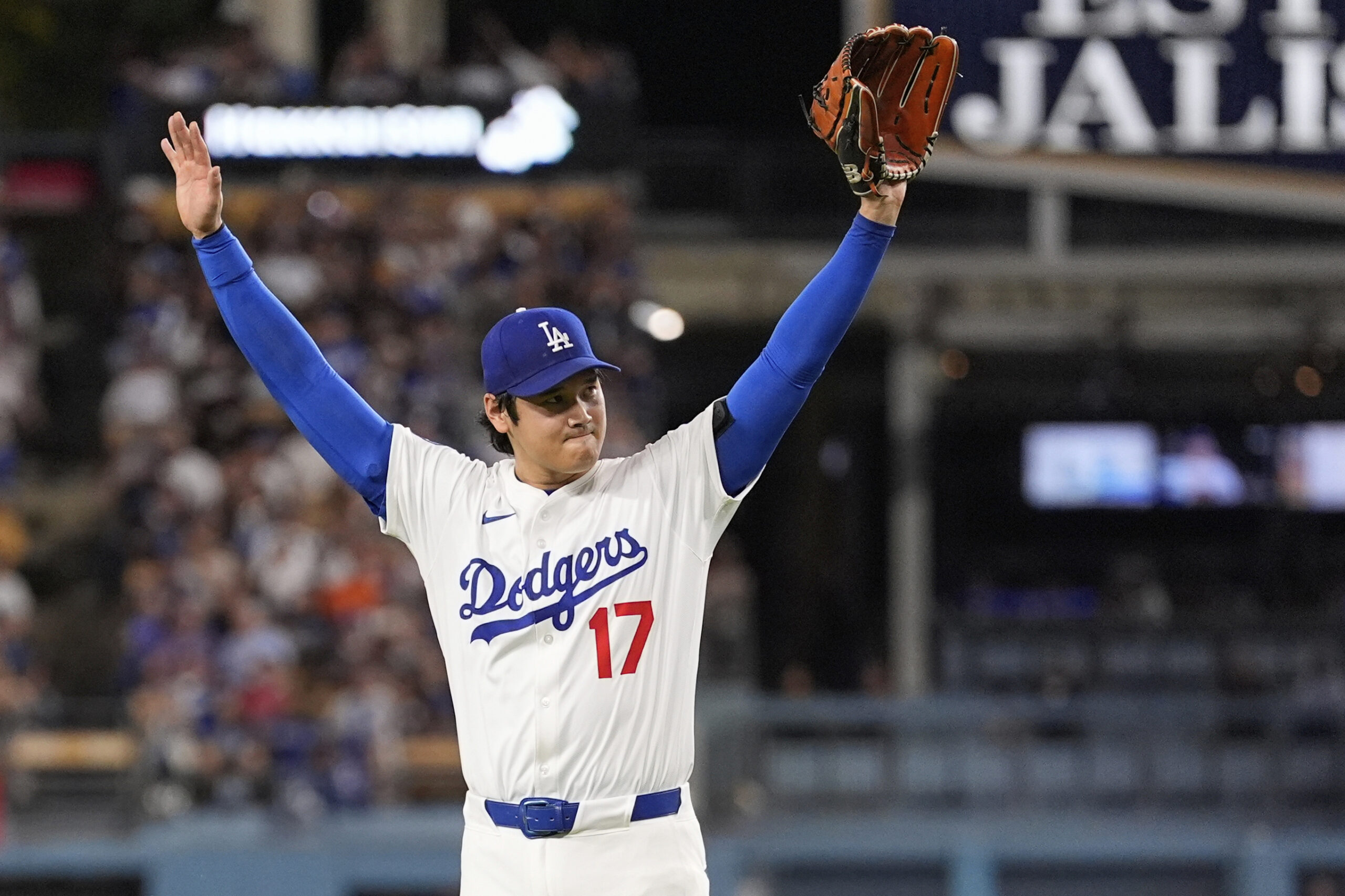 Dodgers starting pitcher Shohei Ohtani celebrates after a fly out...
