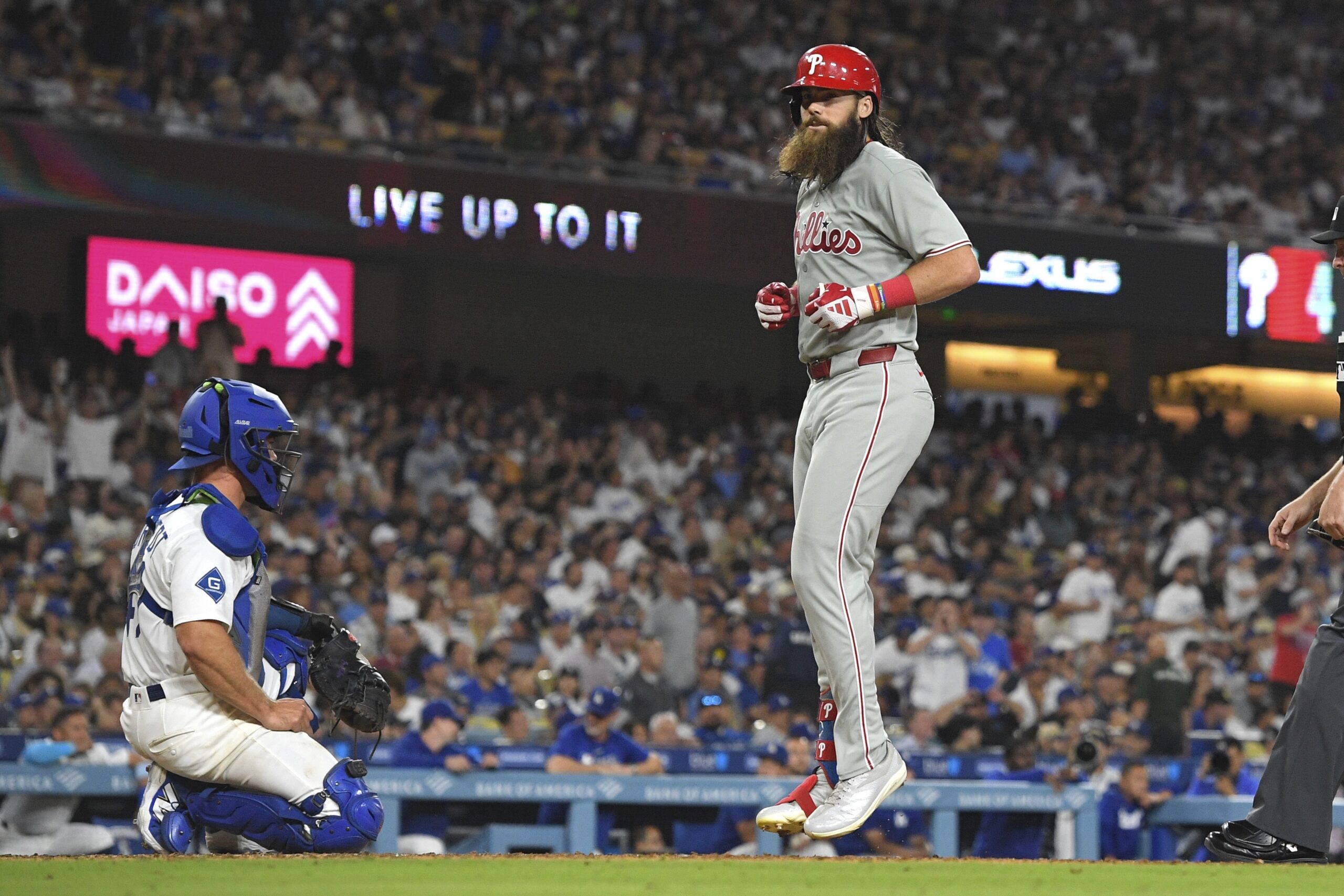 The Philadelphia Phillies’ Brandon Marsh, right, scores after hitting a...