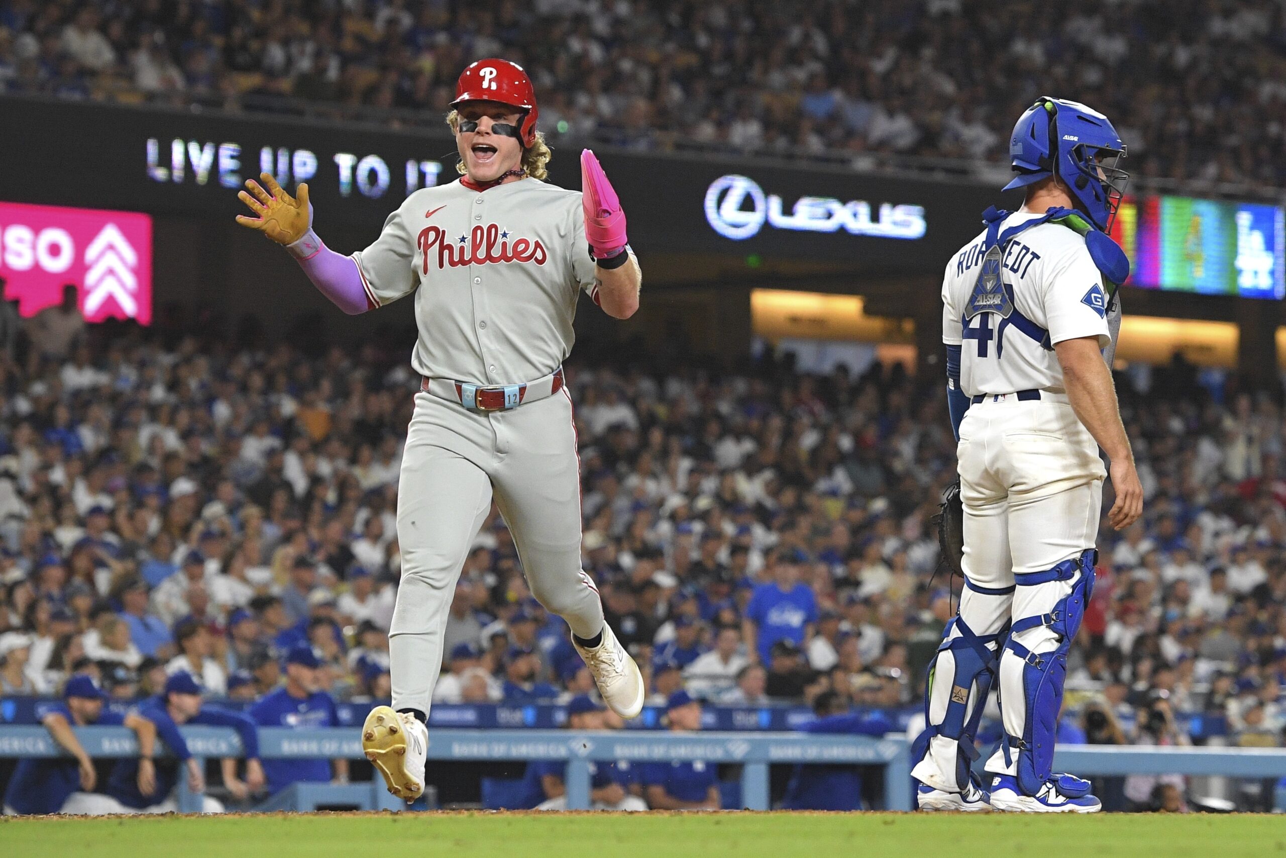 The Philadelphia Phillies’ Harrison Bader, left, scores on a double...